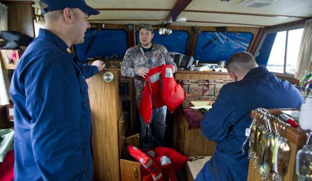 A fishermen shows Coast Guard inspectors the life jackets on his power troller in 2015. (Juneau Empire file)