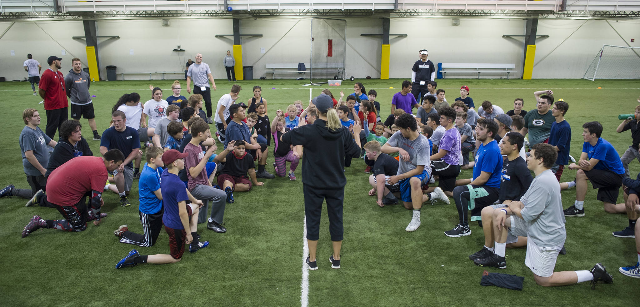 Cori Metzgar, Director of Sports Performance at Western Oregon University and host of the Juneau Football and Sports Performance Camp, speaks to athletes at the Dimond Park Field House last July. (Michael Penn | Juneau Empire File)