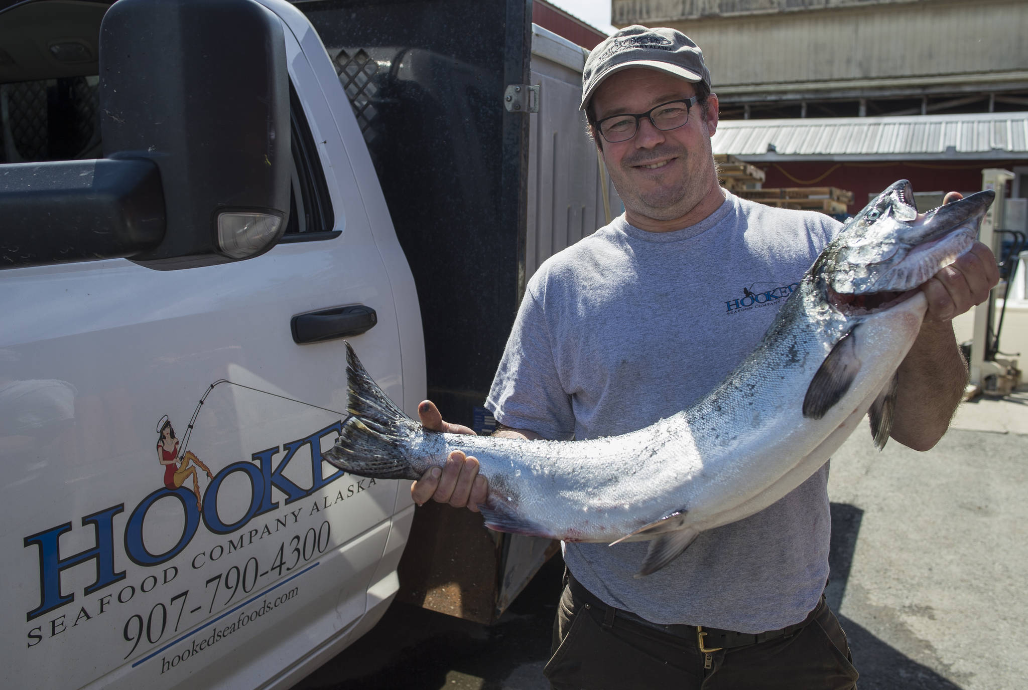 Brad Robbins, the new owner of the Hooked Seafood Company, holds a fresh king salmon at their Industrial Boulevard location on Tuesday, June 19, 2018. (Michael Penn | Juneau Empire)