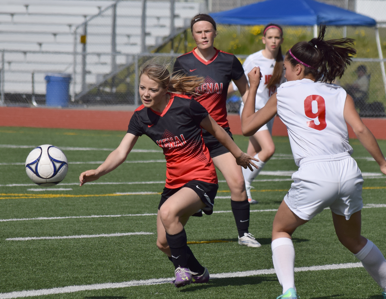 Kenai Central freshman Hayley Maw (center) chases the ball against Juneau-Douglas Friday afternoon at Eagle River High School. JDHS won 3-1.