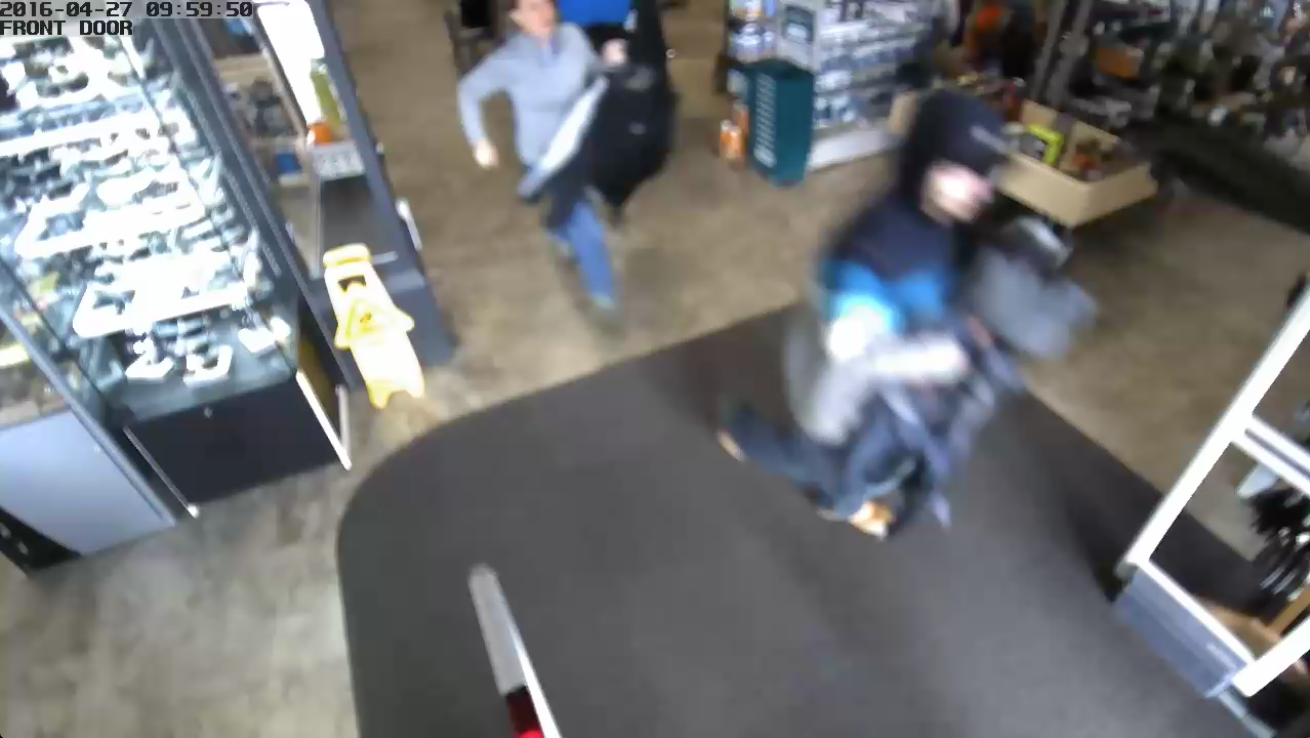 In this still image from security footage, a man can be seen leaving the Nugget Alaskan Outfitter as a woman tries to stop him from exiting without paying for the merchandise in his hands.