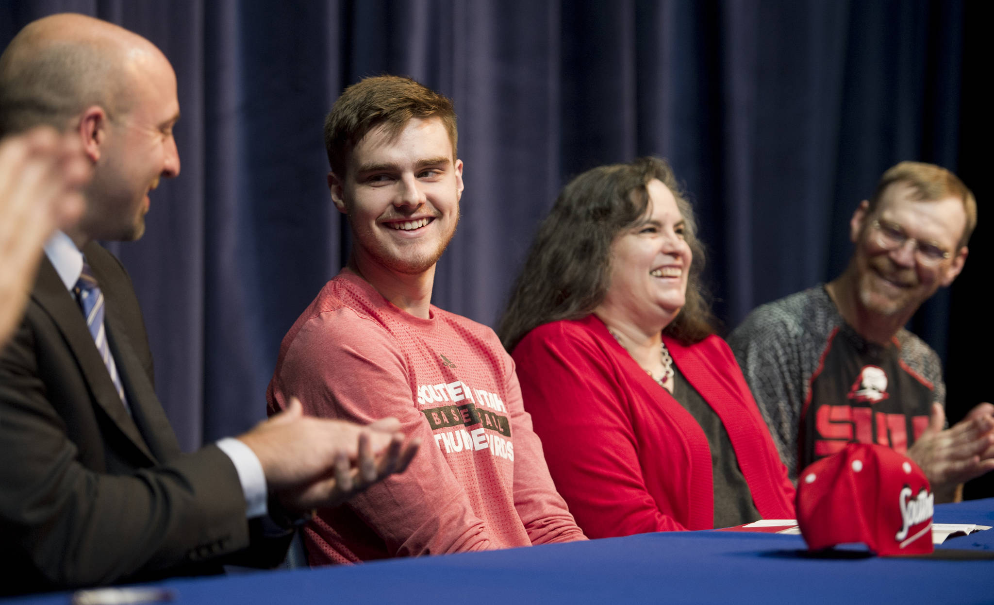 In this May 6, 2016 photo, Jacob Calloway, a 2015 graduate of Thunder Mountain High School, is applauded by his parents, Virginia and Roger Calloway, right, and TMHS basketball coach John Blasco, right, after signing to play Division 1 basketball for Southern Utah University. (Michael Penn | Juneau Empire File)