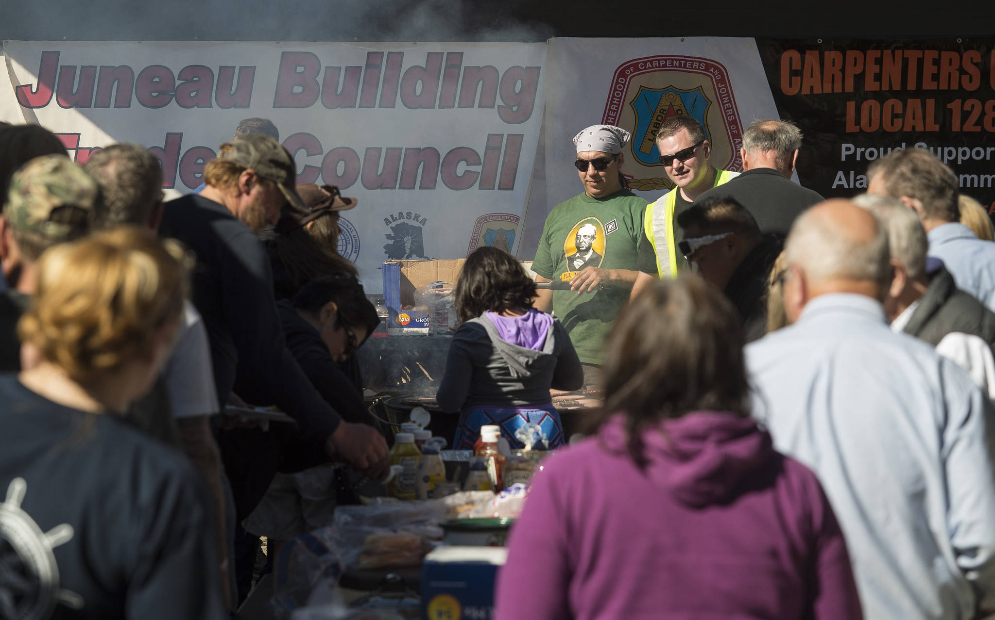 Local union members Kirk Perisch, left, Corey Baxter cook hot dogs and hamburgers for those attending the Labor Day picnic at Sandy Beach on Monday, Sept. 3, 2018. (Michael Penn | Juneau Empire)