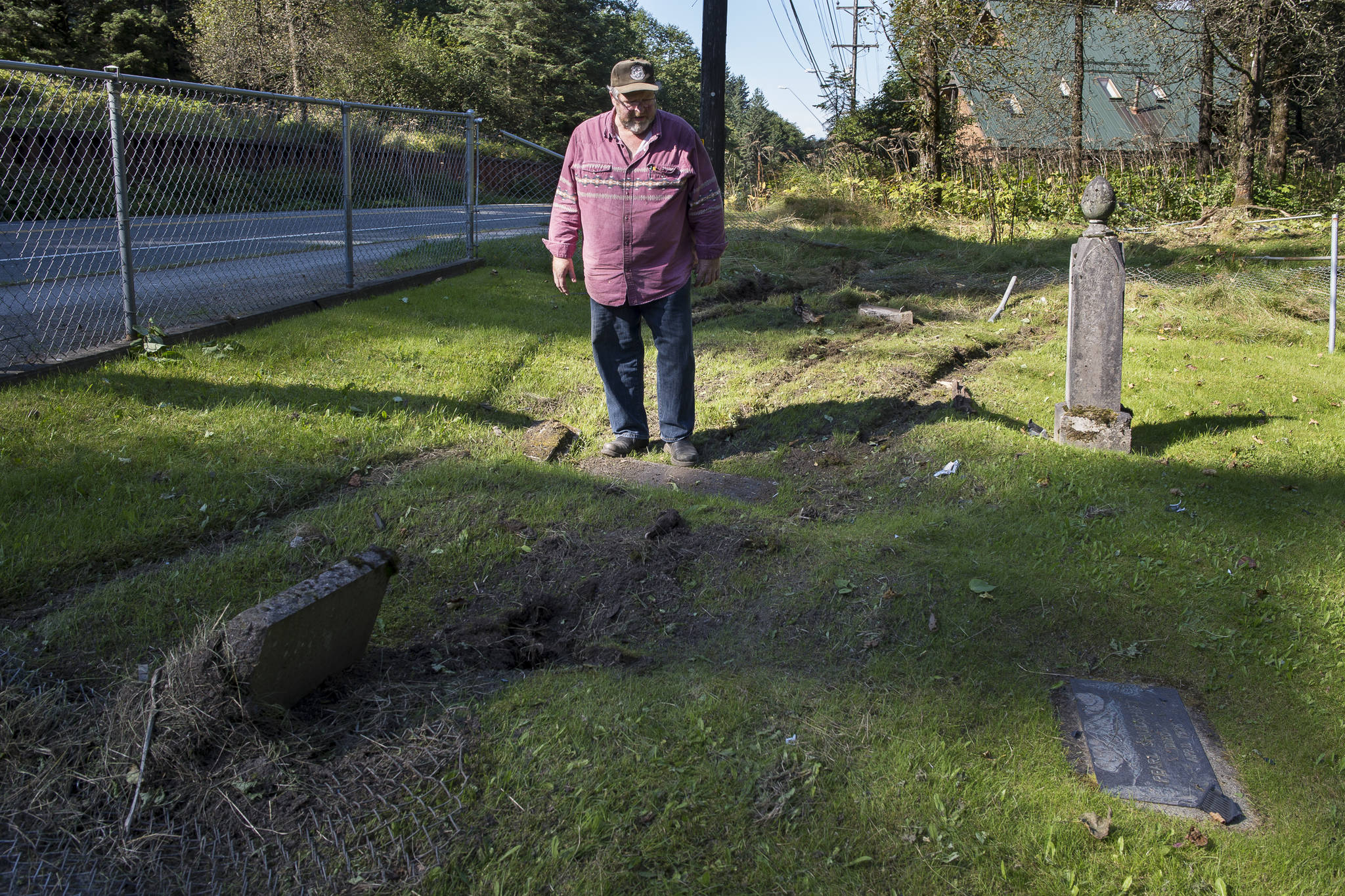 Former Mayor Merrill Sanford examines the damage done to the Eagles Cemetery in Douglas on Thursday, Sept. 6, 2018. A vehicle drove through the cemetery early Thursday morning. Sanford owns the property. (Michael Penn | Juneau Empire)