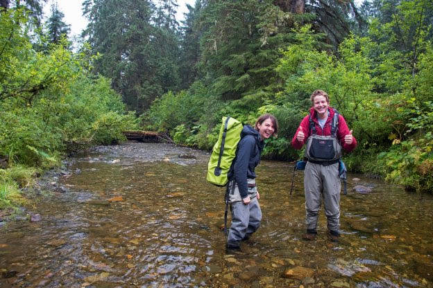 UAS Environmental Science Students Mollie Dwyer, left and Connor Johnson trek through Montana Creek to obtain water samples Thursday, Aug. 23, 2018 in Juneau, Alaska. (Photo by Molly Tankersley, UAS)