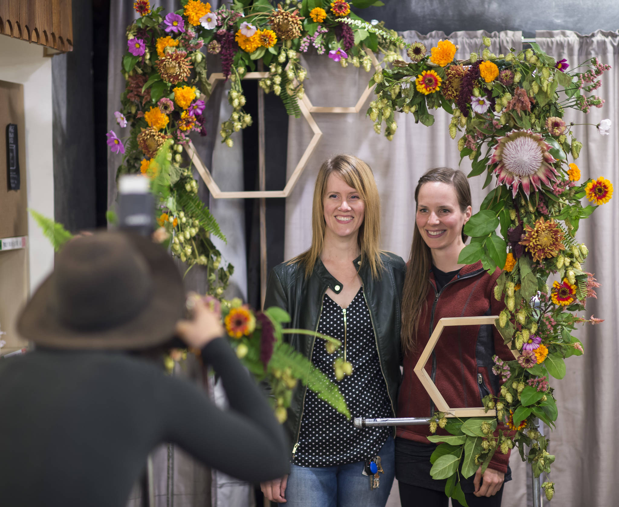 Photographer Kaley McGoey photographs Kelsey Smioley, center, and Kayla Koelling at the Fera + Frenchie’s Photobooth in Kindred Post during First Friday on Friday, Sept. 7, 2018. (Michael Penn | Juneau Empire)
