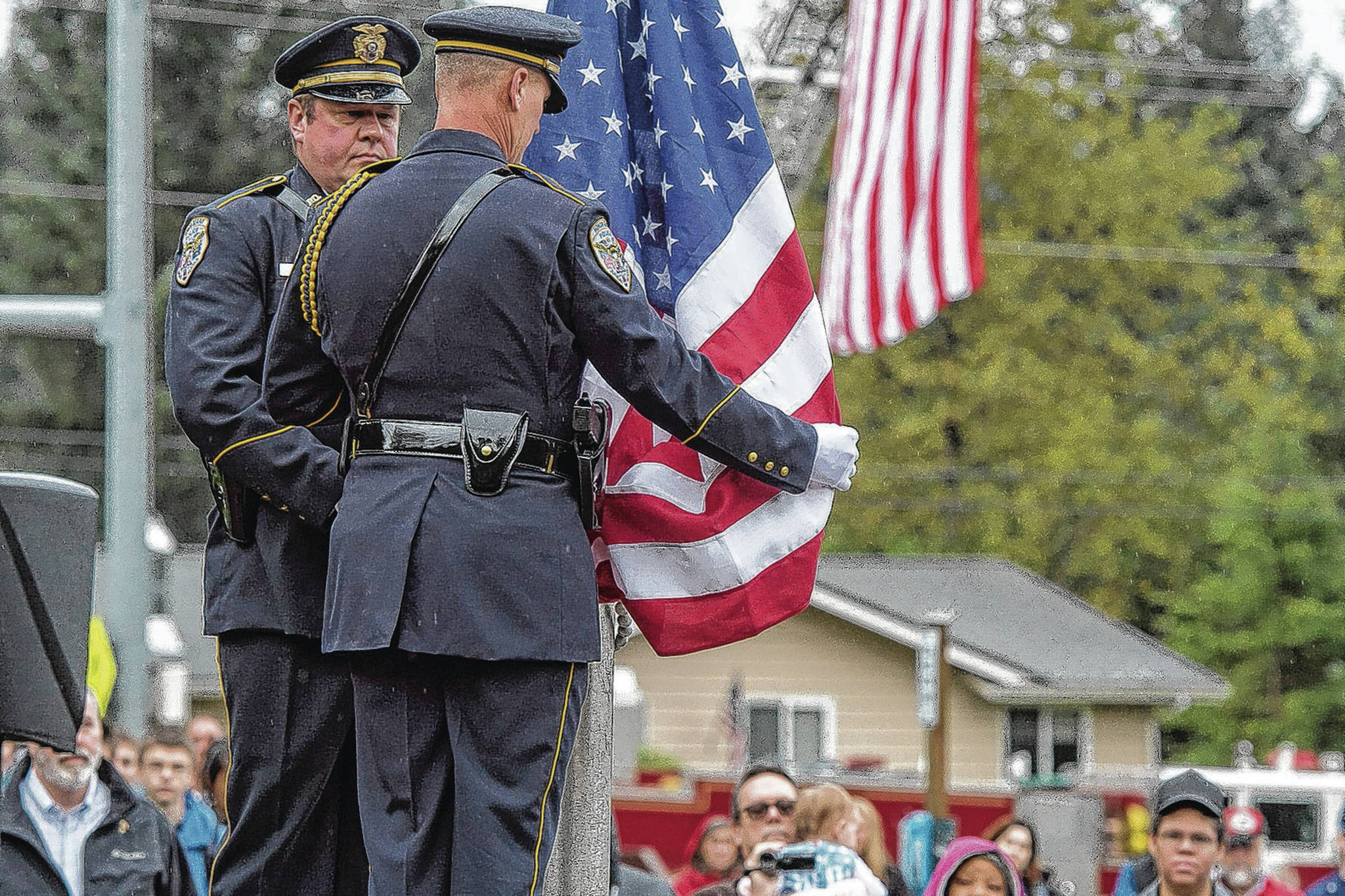 Juneau Police Department Honor Guard members Off. Mike Wise, right, and Off. Jeff Brink install the flag during the September 11 Memorial Ceremony at Rotary Park on Monday, Sept. 11, 2017. (Michael Penn | Juneau Empire File)
