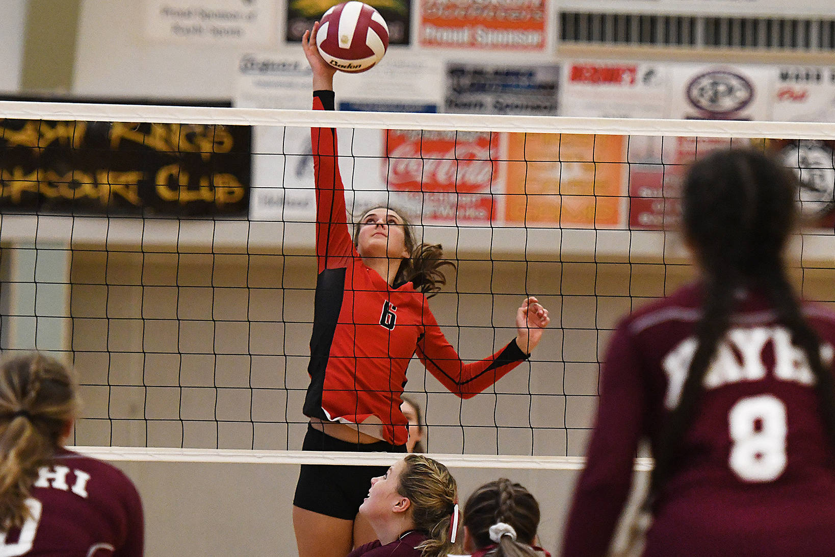 Juneau Douglas middle blocker Addie Prussing taps the ball over the net during a 3-0 victory over the Ketchikan Kings on Saturday. (Dustin Safranek | Ketchikan Daily News)