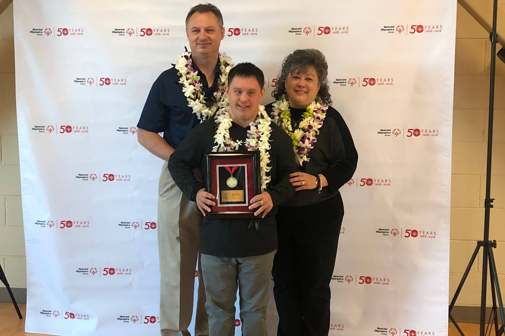 Chris, CJ and Michelle Umbs accept their Family of the Year award from the Special Olympics Alaska’s “Breakfast With Champions” event at the Special Olympics Alaska Sports, Health and Wellness Center in Anchorage on Wednesday morning. (Courtesy Photo | Gail Fenumiai)