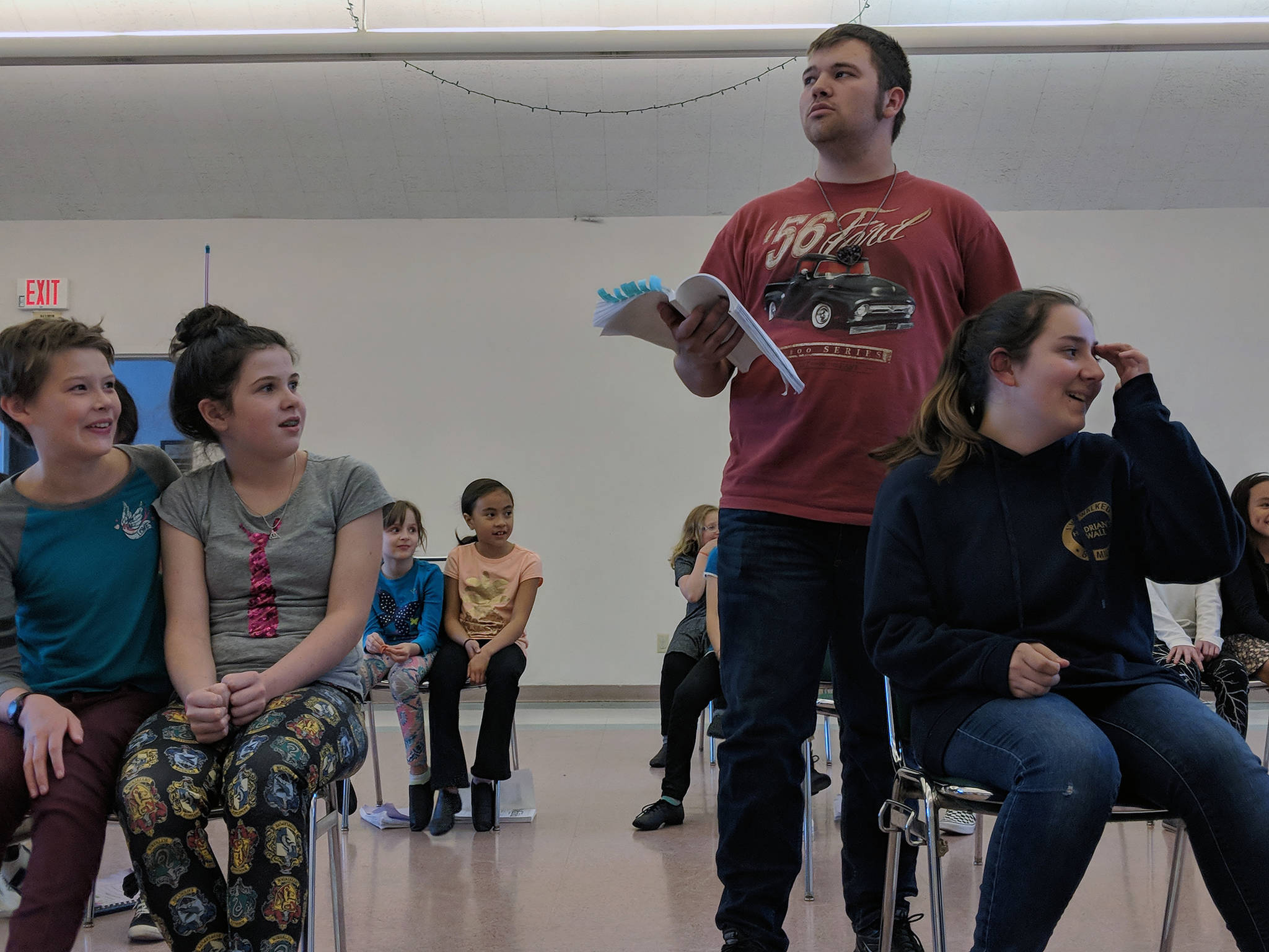 Reagan Mitchell (far right), portraying Matilda stifles laughter in the stern presence of Jared Vance’s Miss Trunchbull, while classmates (from left to right) Dannan Mills, Dori Germain, Adina Alper and Kaia Mangaccat look on during a rehearsal of “Matilda,” a musical production to be put on by Theater at Latitude 58. (Ben Hohenstatt | Capital City Weekly)