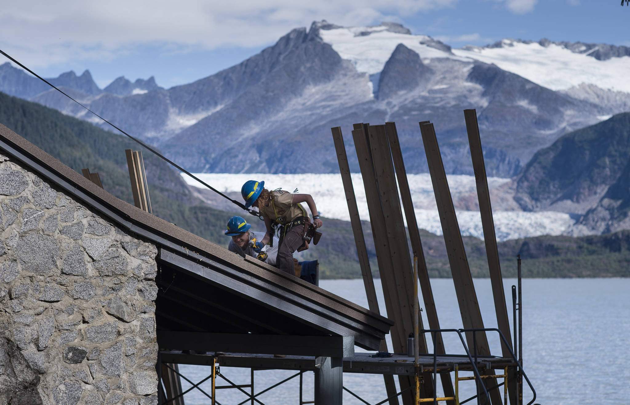 Kenzie Schultz, right, and Maxwell Hertel, both of the U.S. Forest Service, work with a crew to replace the nearly 30-year-old roof on the historic building of Skaters Cabin on Wednesday, Sept. 12, 2018. (Michael Penn | Juneau Empire)