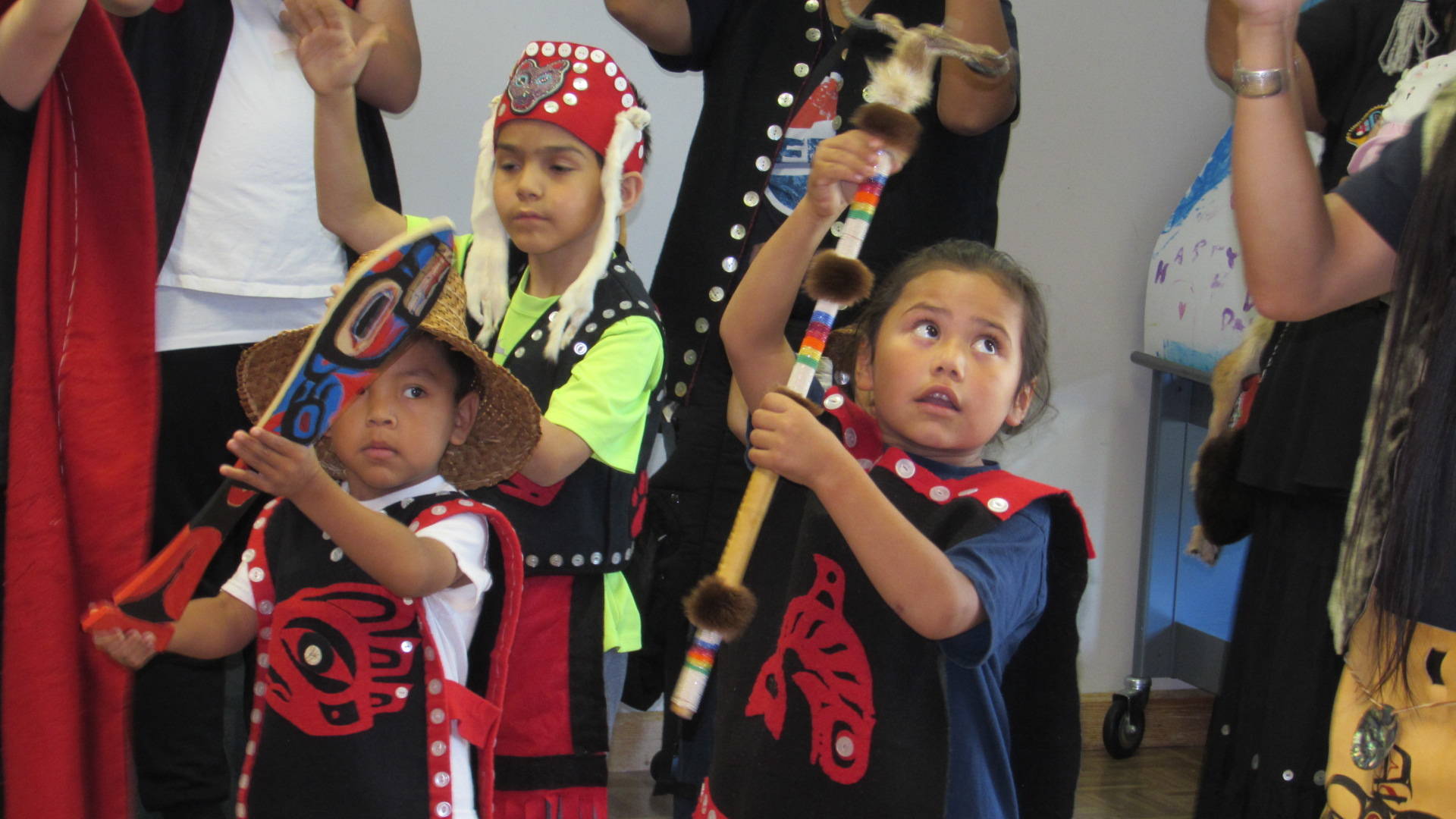 Martin “Junior” Stepetin Jr., Evan Elton and Shaunde Ahshapanek, young members of the Woosh.ji.een Dance Group dance during a Native Culture Festival Saturday at Douglas Public Library. Older members of the group explained the significance of their regalia to a crowd gathered at the library for the festival. (Ben Hohenstatt | Capital City Weekly)