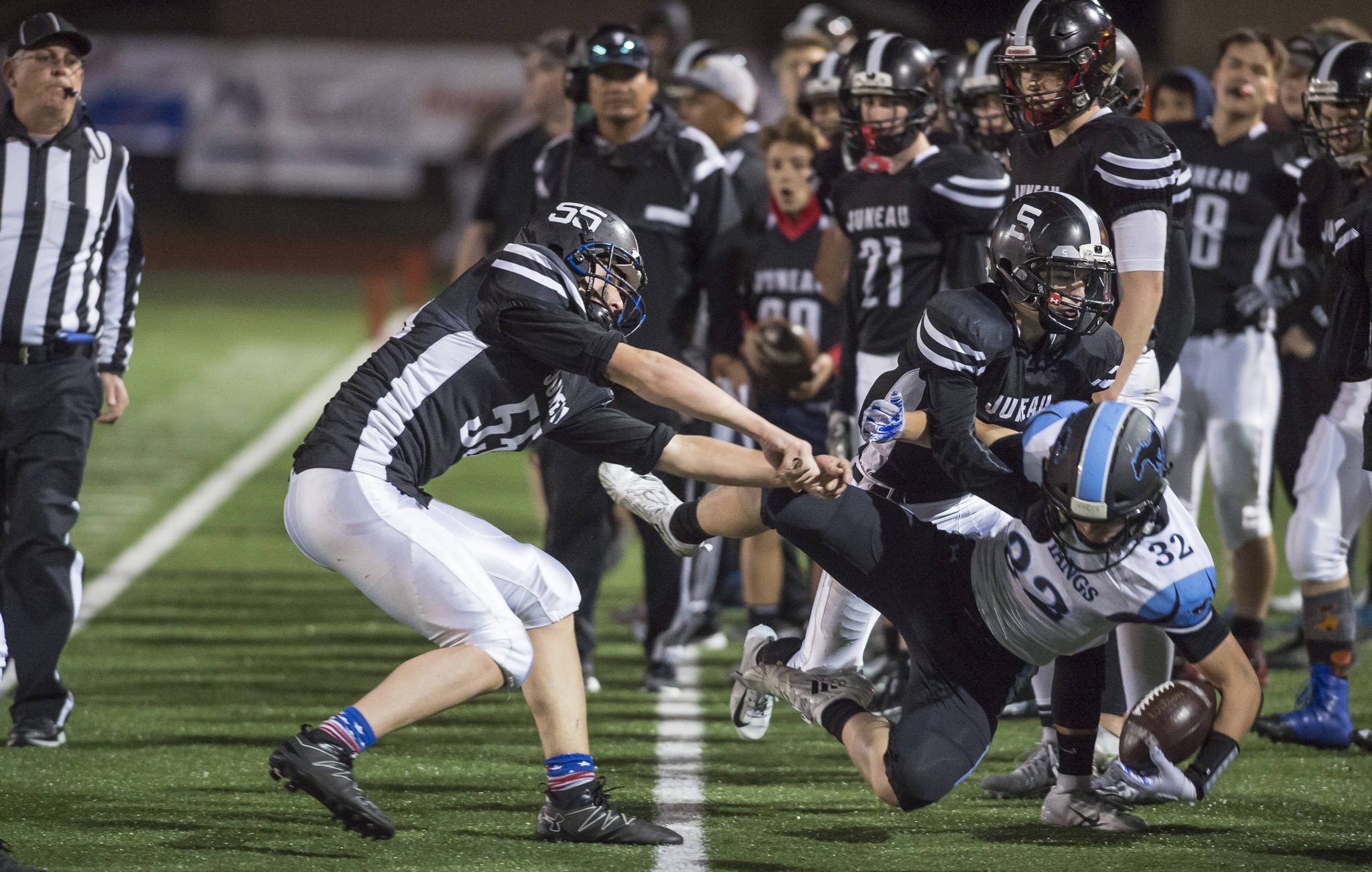 Juneau United’s Gaven Smith, left, and Hansel Hinckle push Chugiak’s Christian Beesing out of play at Adair-Kennedy Memorial Field on Friday, Sept. 14, 2018. A penalty was called on the play. Chugiak won 22-7. (Michael Penn | Juneau Empire)
