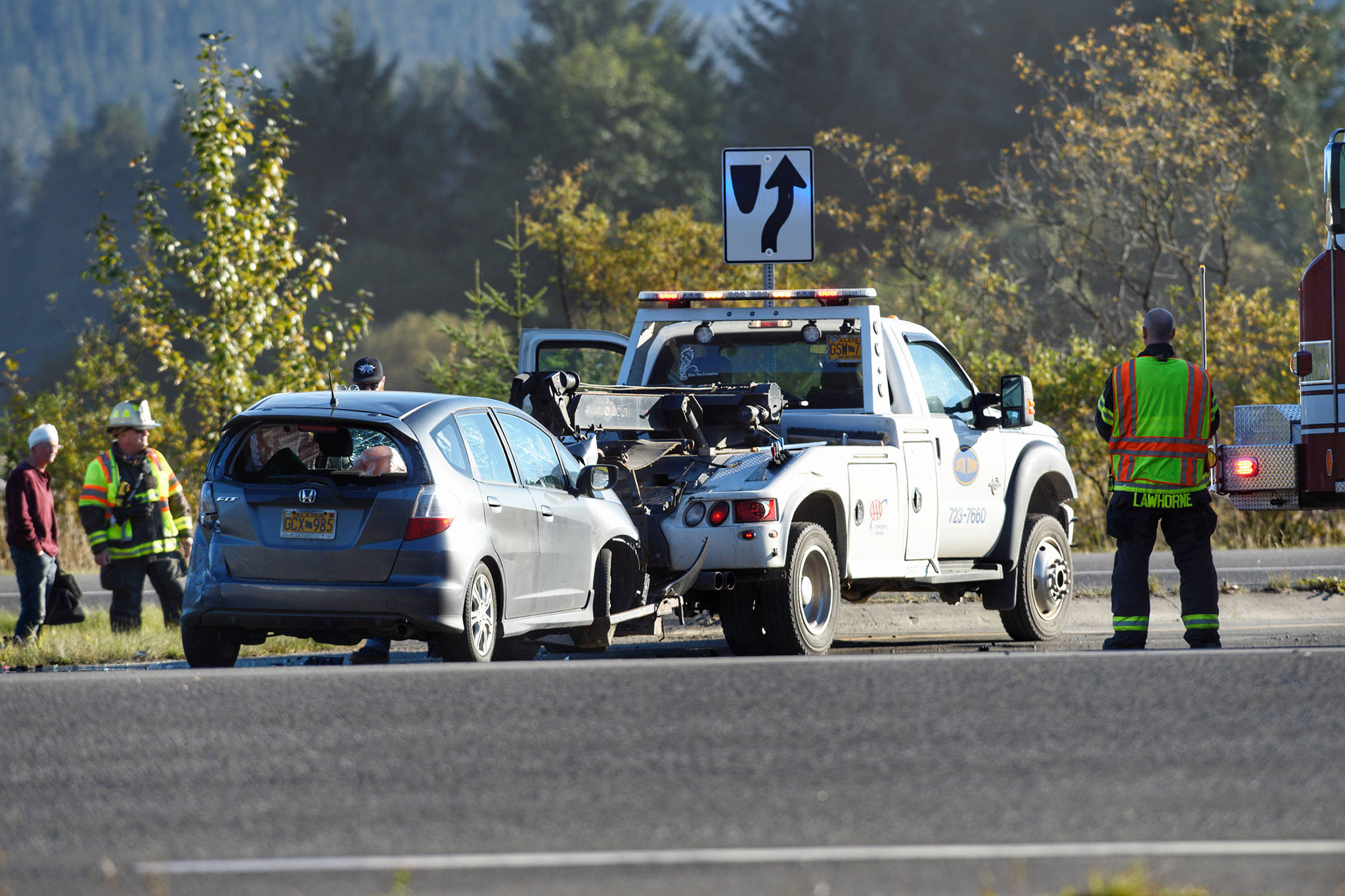 A damaged vehicle is pulled away by a tow truck after an afternoon car crash at the Fred Meyer intersection on Friday. (Michael Penn | Juneau Empire)