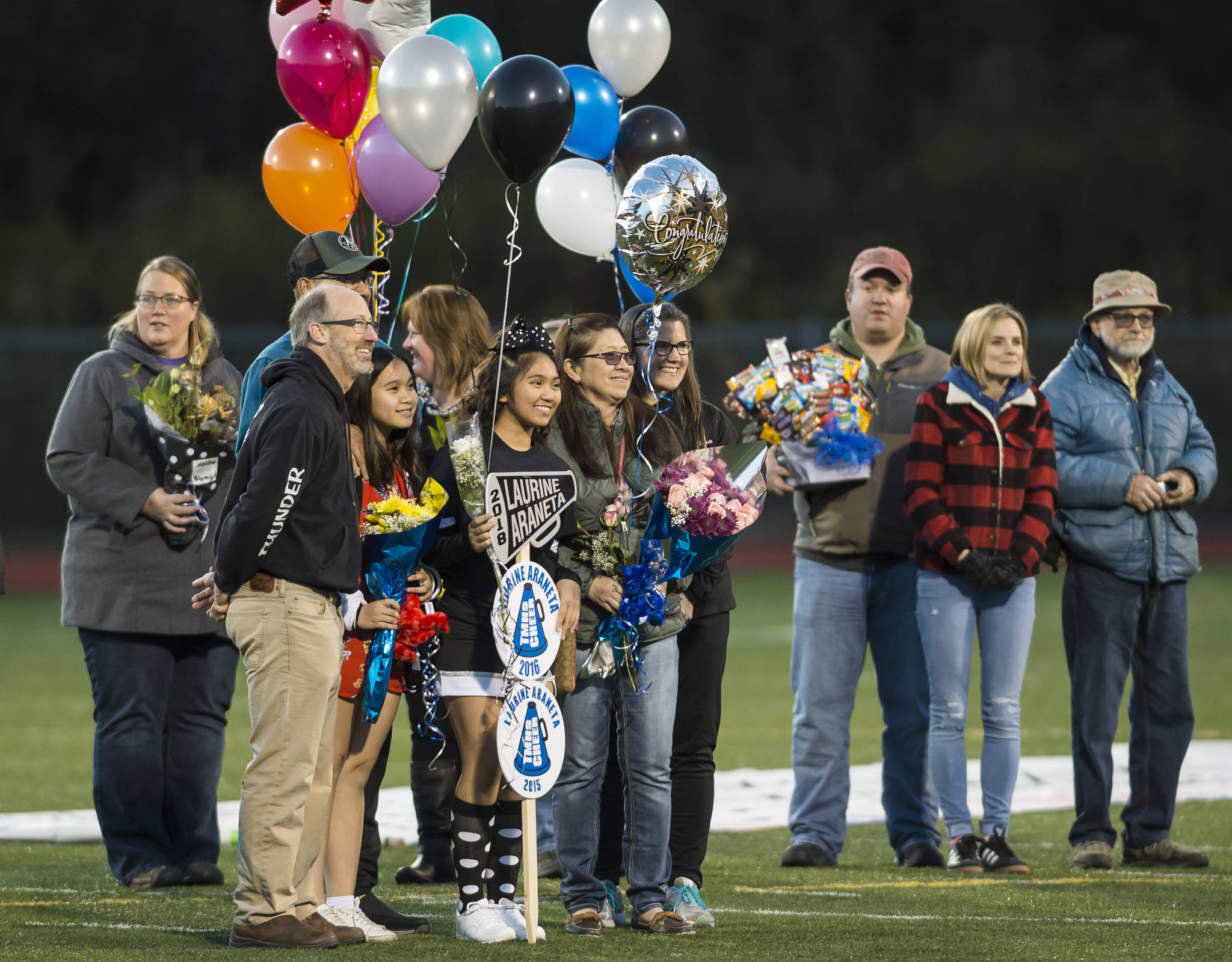 Family and friends celebrate senior night with cheerleaders and players before Juneau United’s game against Colony at Thunder Mountain High School on Friday, Sept. 21, 2018. (Michael Penn | Juneau Empire)