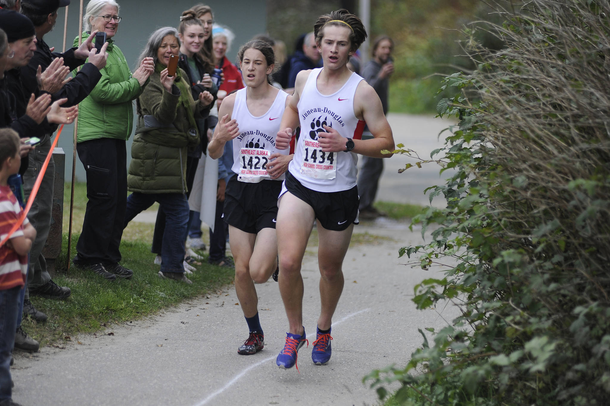Juneau-Douglas’ Clem Taylor-Roth, right, and Ambrose Bucy, race toward the finish line of the Region V Cross Country Championship meet on Saturday. (Nolin Ainsworth | Juneau Empire)