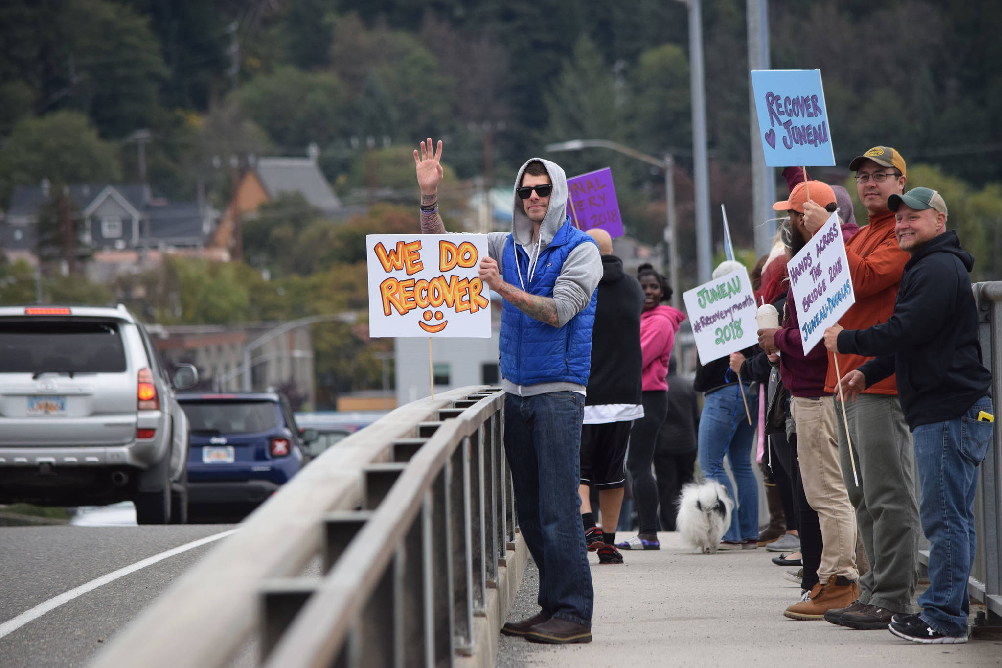 William Musser waves to passing cars on the Douglas Bridge on Saturday, Sept. 22, during the Hands Across the Bridge event, which aims to spread awareness about substance use recovery in Juneau. (Kevin Gullufsen | Juneau Empire)