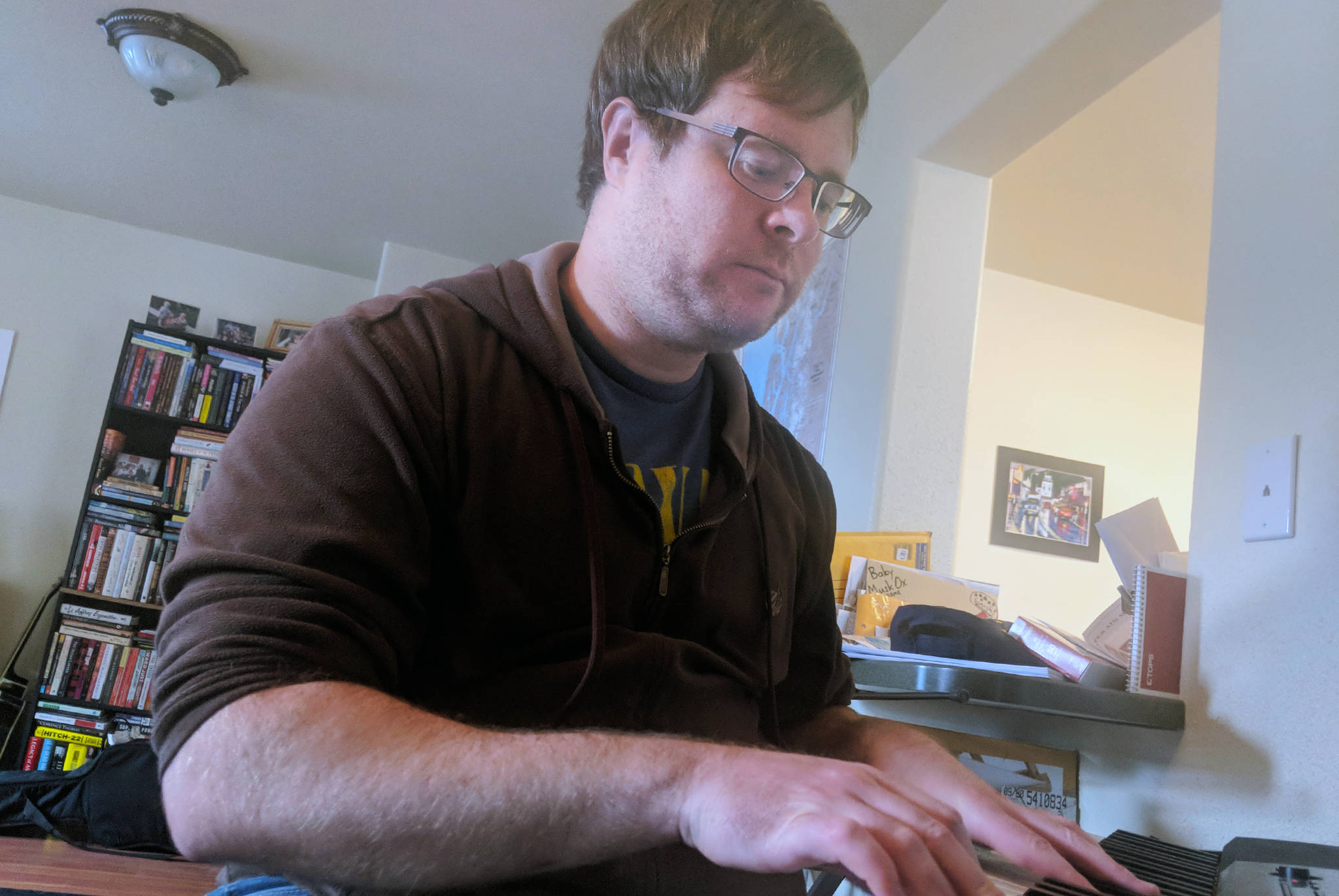Andy Miller plays keyboard in his Juneau apartment. The instrument features prominently on the recently released “Alaska in 28 Songs.” (Ben Hohenstatt | Capital City Weekly)