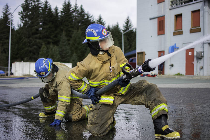 JDHS student Finn Adam (left) and homeschool student James Zuiderduin (right), Capital City Fire/Rescue cadets, practice advancing a hose under pressure at their final day of training with the CCFD on Saturday, April 21, 2018. (Richard McGrail | Juneau Empire File)