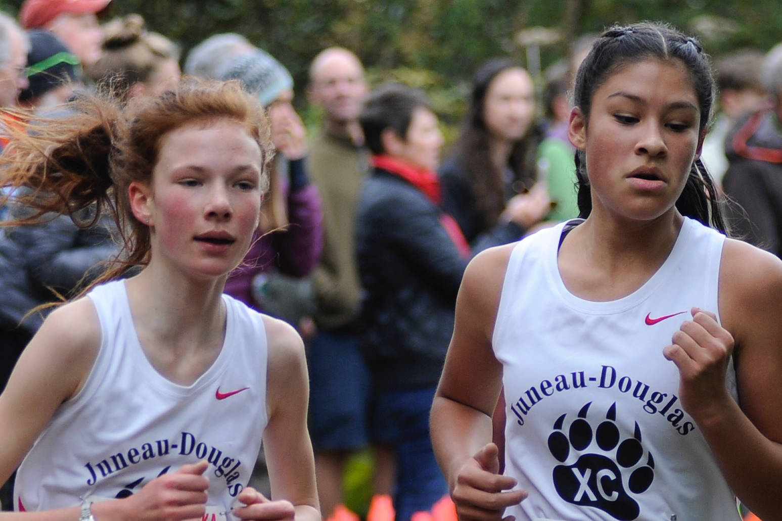 Juneau-Douglas High School’s Annika Schwartz, left, and Trinity Jackson compete in the Region V Cross Country Running Championships Division I race on the Treadwell Mine Historic Trails on Saturday. (Nolin Ainsworth | Juneau Empire)