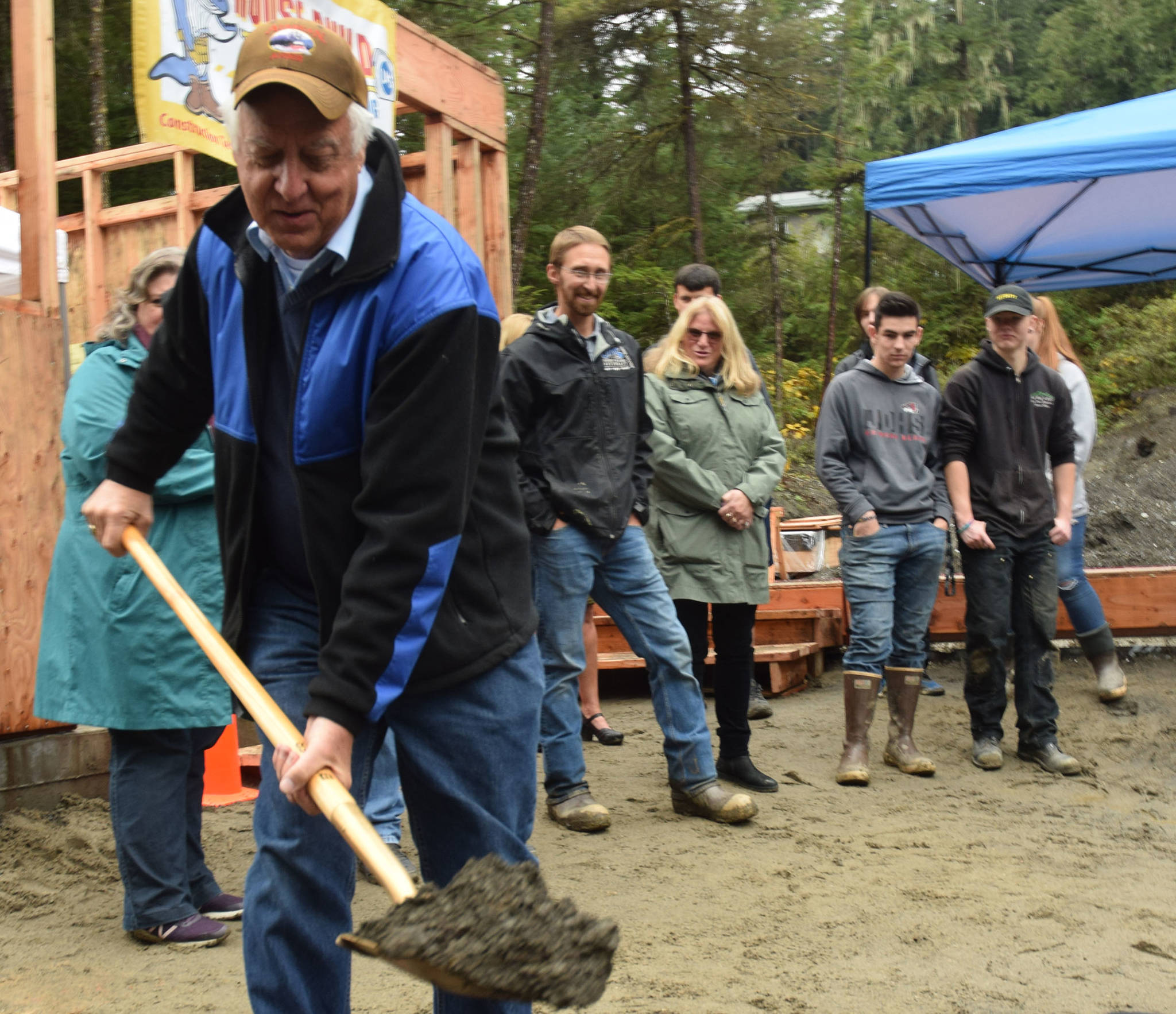 Mayor Ken Koelsch digs a shovel full of dirt at a Wednesday dedication ceremony for Jackie Street Cottages, an affordable housing project in Lemon Creek. (Kevin Gullufsen | Juneau Empire)