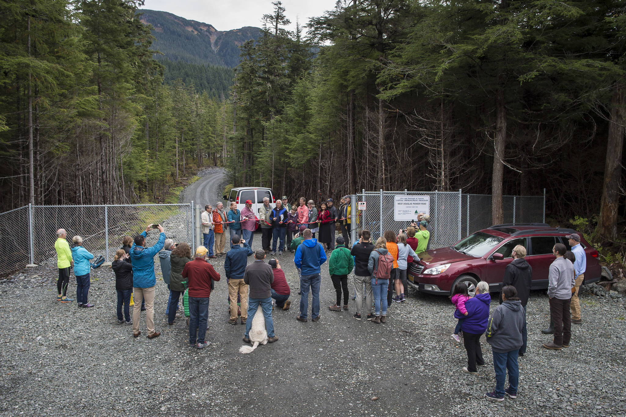 A small audience watches as city officials hold a ribbon cutting ceremony to officially open the West Douglas Pioneer Road on Friday, Sept. 28, 2018. (Michael Penn | Juneau Empire)