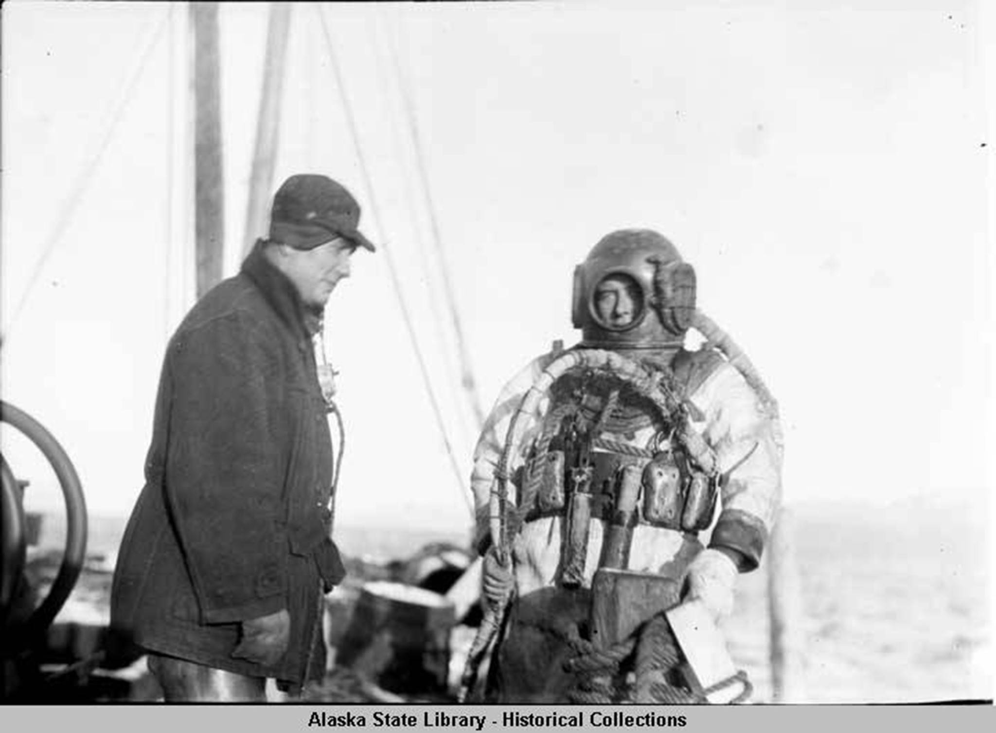 Diver in helmet and diving suit, preparing to descend to the Princess Sophia. (Alaska State Library Historical Collection, ASL-P87-1718)
