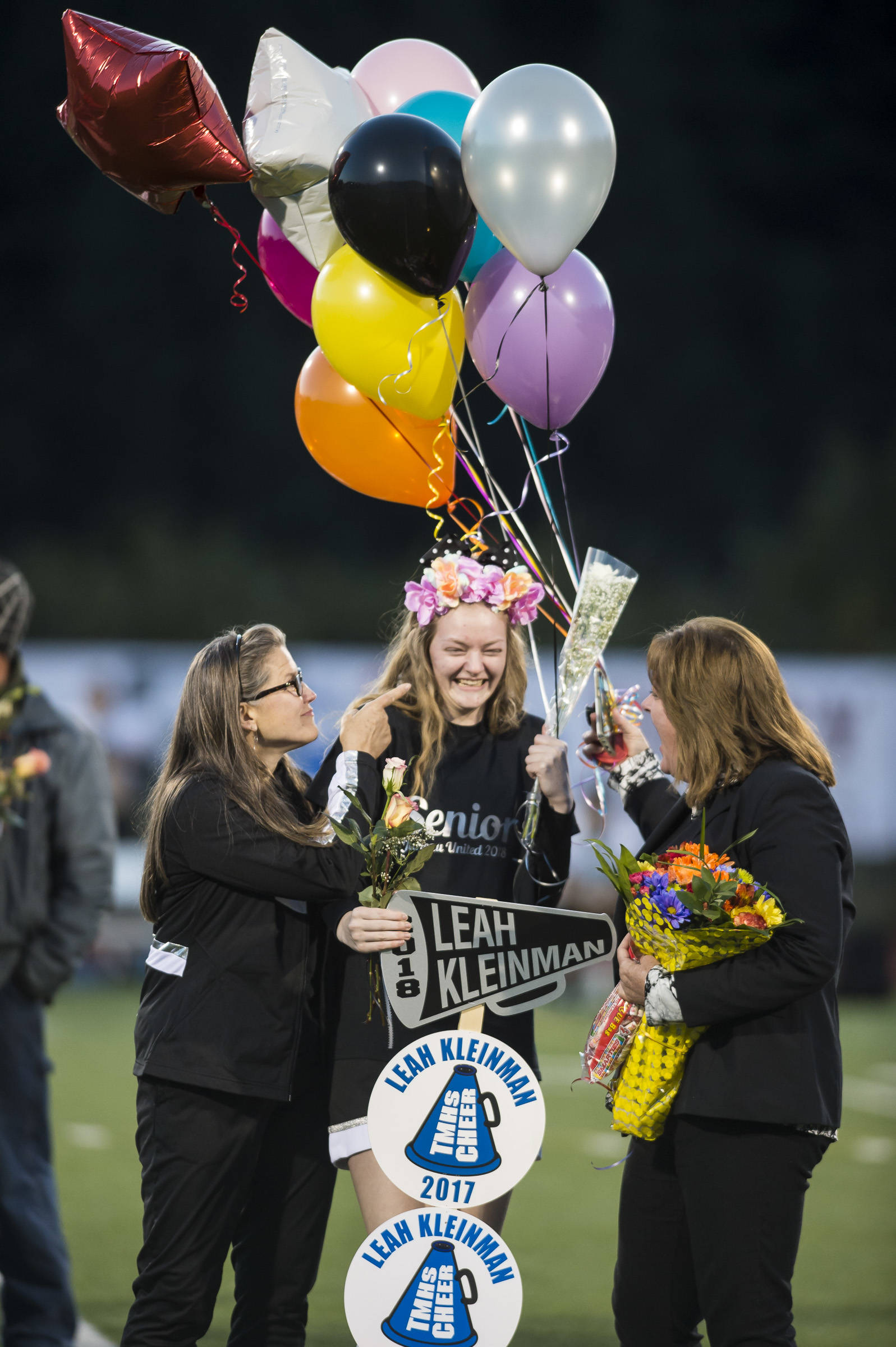 Family and friends celebrate senior night with cheerleaders and players before Juneau United’s game against Colony at Thunder Mountain High School on Friday, Sept. 21, 2018. (Michael Penn | Juneau Empire)