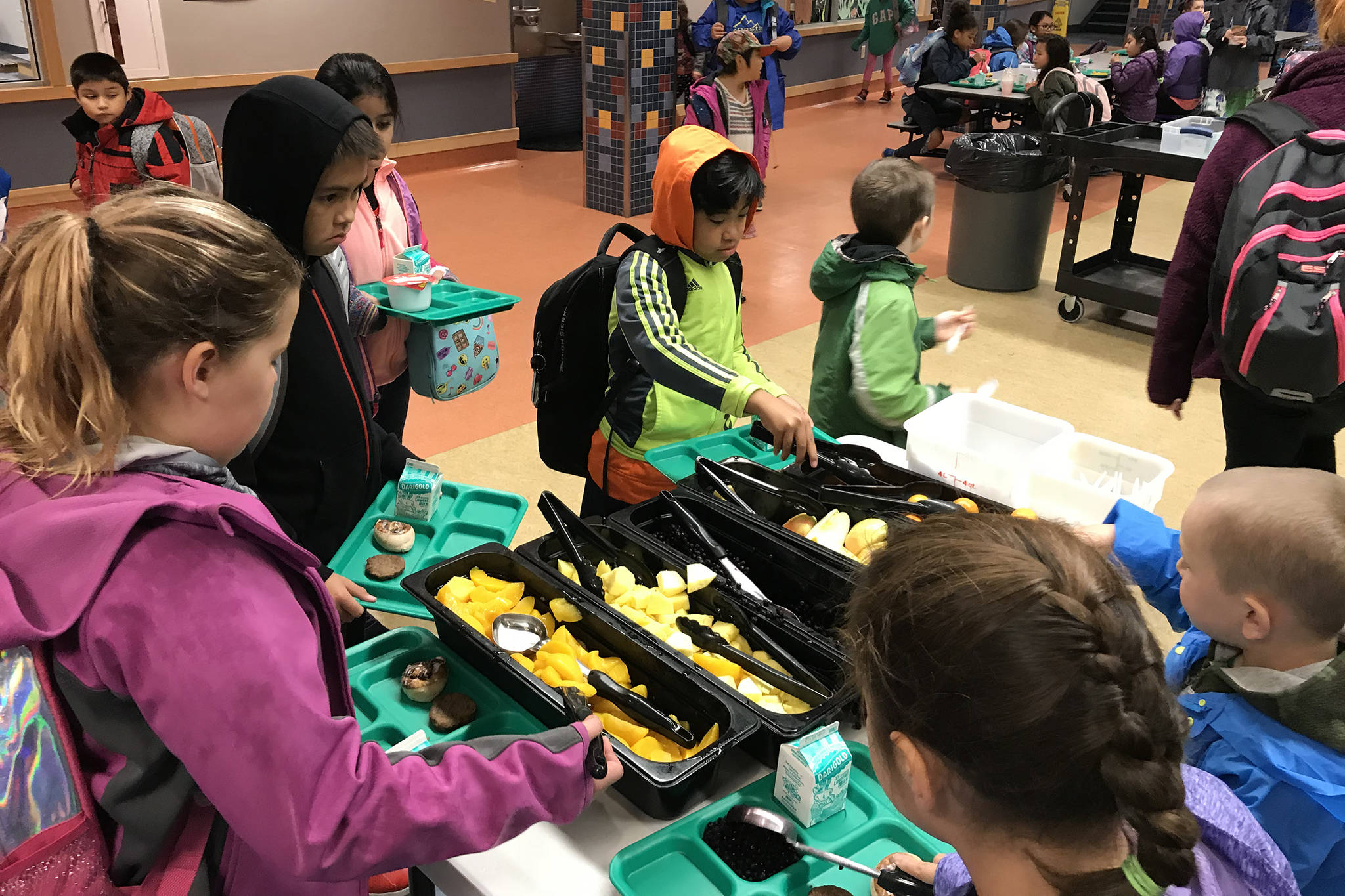 Harborview Elementary School students load up on fruit at a free school breakfast on Friday, Oct. 5, 2018. (Kevin Gullufsen | Juneau Empire)