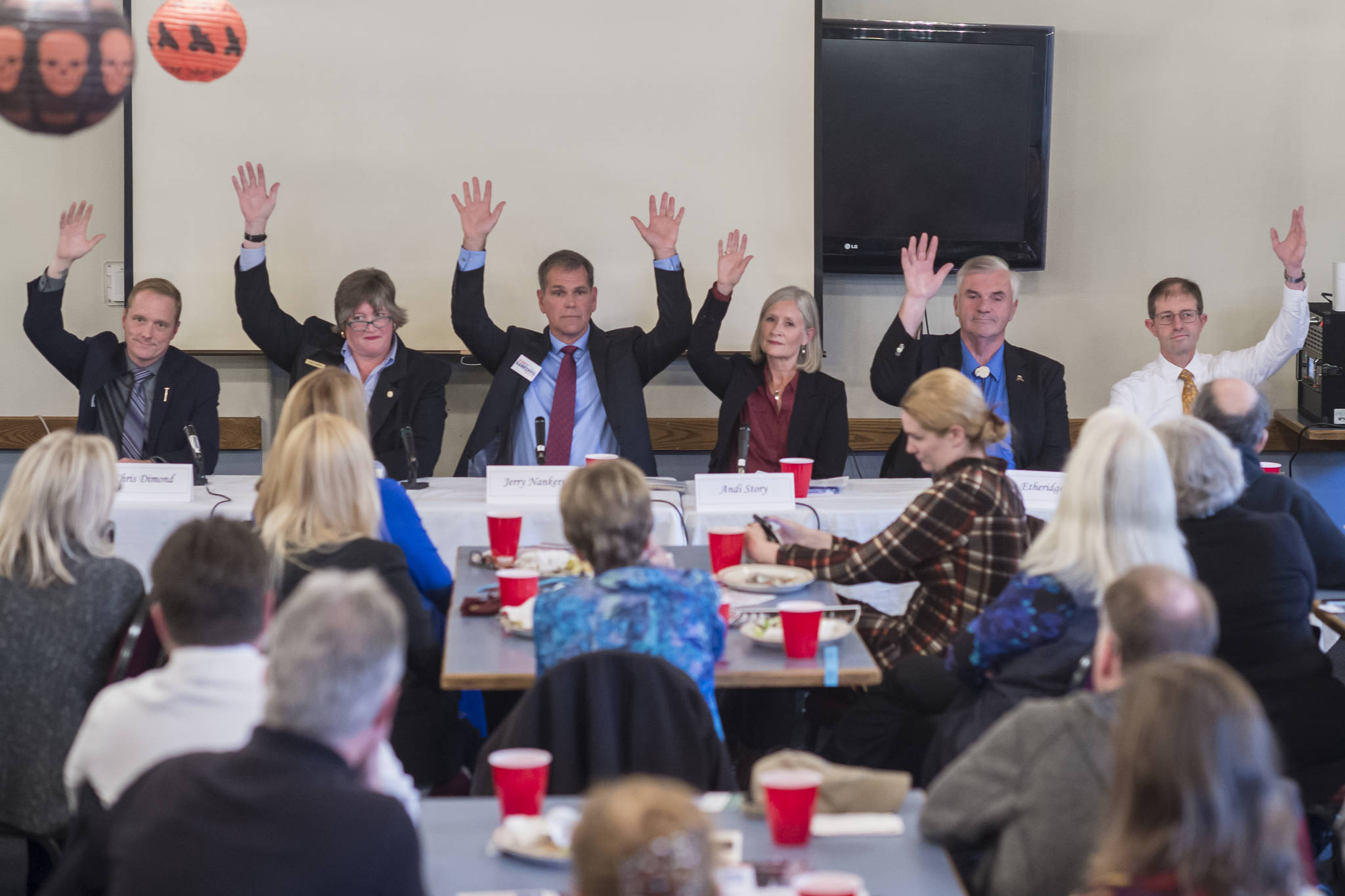 Juneau legislative candidates raise their hands to show they are in favor of a second crossing to Douglas Island during a forum at the Juneau Chamber of Commerce luncheon at the Moose Lodge on Thursday, Oct. 4, 2018. From left: House District 33 candidates Chris Dimond and Sara Hannan, House District 34 candidates Jerry Nankervis and Andi Story, and Senate District Q candidates Don Etheridge and Jesse Kiehl. (Michael Penn | Juneau Empire)