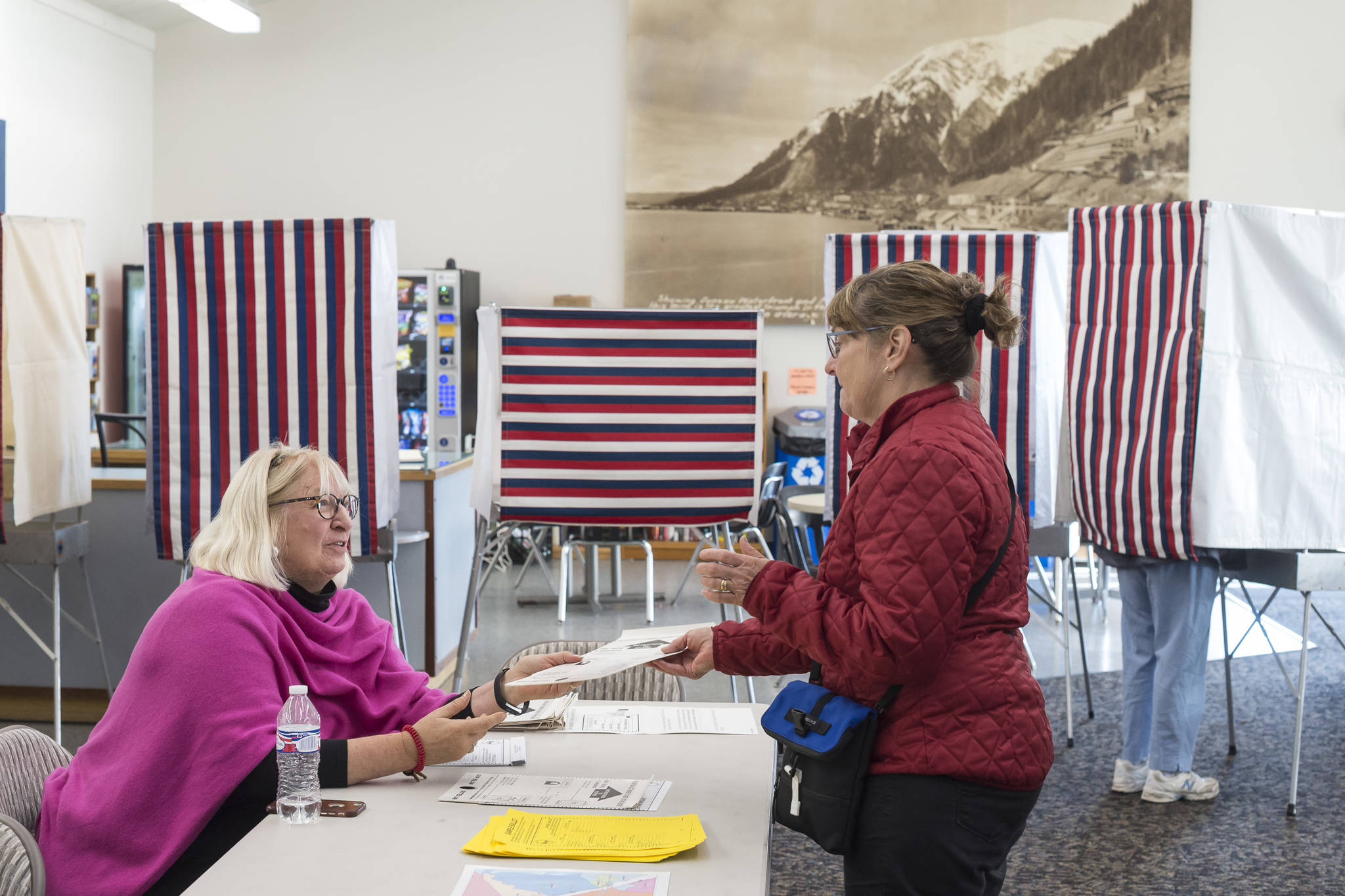 Election official Jacqueline Fowler, left, hands Becky Dierking her ballot in the Municipal Election at the Auke Bay Ferry Terminal on Tuesday, Oct. 2, 2018. (Michael Penn | Juneau Empire)