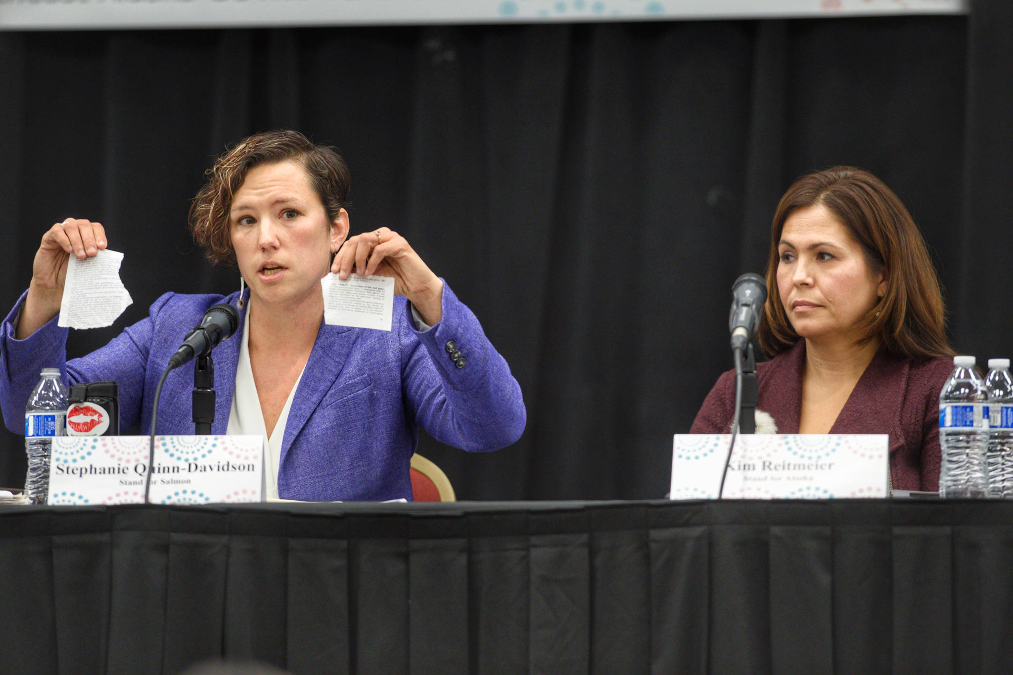 Stephanie Quinn-Davidson, left, of Yes for Salmon, holds up what she says is habitat protection regulation as she debates the merits of Ballot Measure 1 with Kim Reitmeier, representing Stand for Alaska, during a Get Out the Native Vote Southeast forum at Elizabeth Peratrovich Hall on Tuesday, Oct. 9, 2018. (Michael Penn | Juneau Empire)