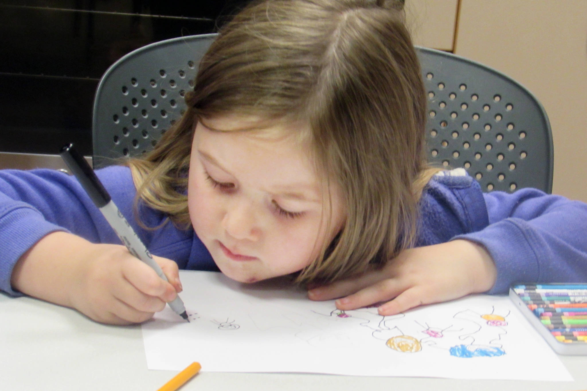 Zuriel Kerr, 4, works on coloring her monster during a How to Make a Monster workshop with artist Glo Rameriz Saturday afternoon at Douglas Public Library.(Ben Hohenstatt | Capital City Weekly)