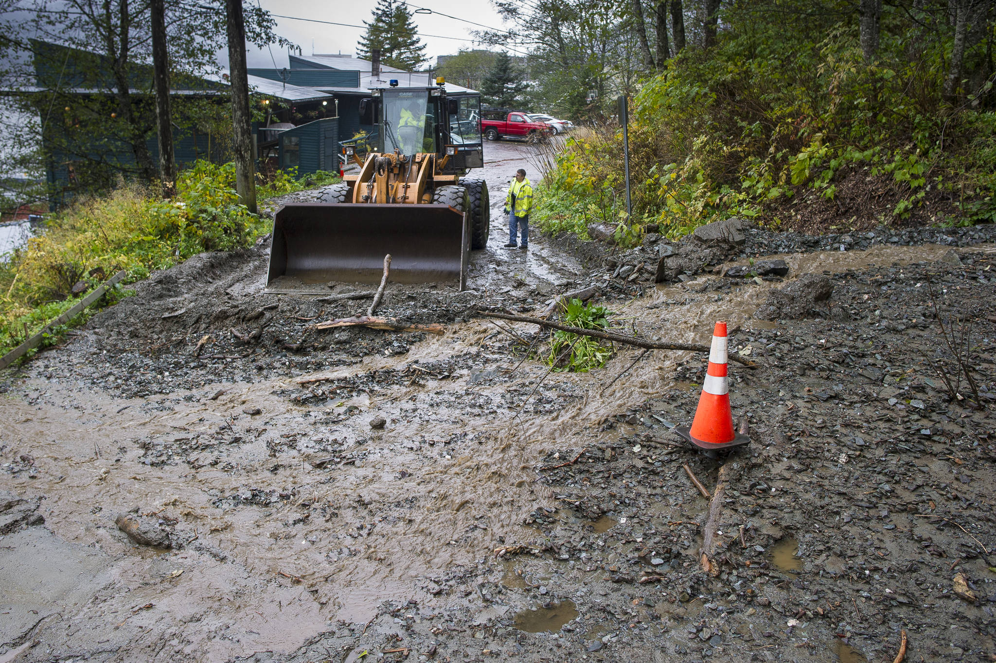 A city maintainance crew waits for equipment to clean up a small mud slide at the south end of Gastineau Avenue on Monday, Oct. 15, 2018. (Michael Penn | Juneau Empire)