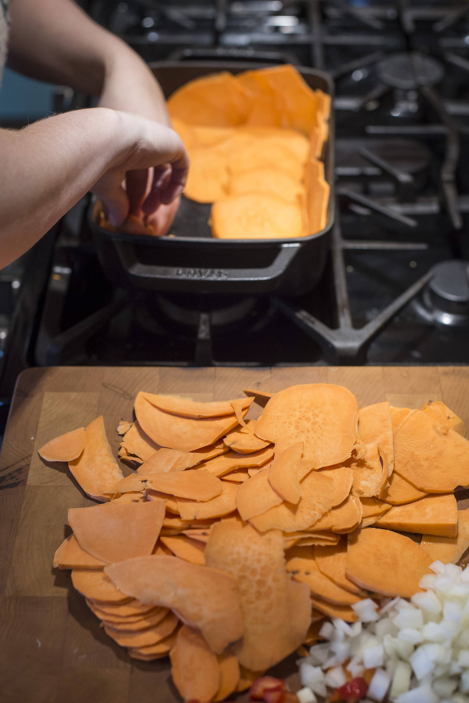 Erin Anais Heist lines a baking pan with sweet potato slices for a quiche in her home kitchen on Thursday, Oct. 4, 2018. (Michael Penn | Juneau Empire)