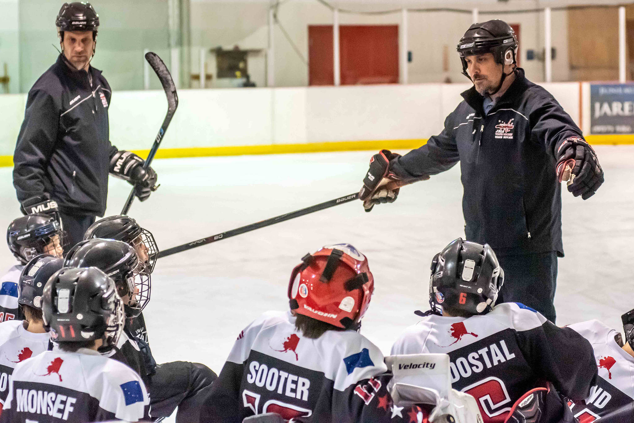 Juneau Capitals 12U AA coach Dave Kovach, left, instructs his players during practice. (Courtesy Photo | Steve Quinn)