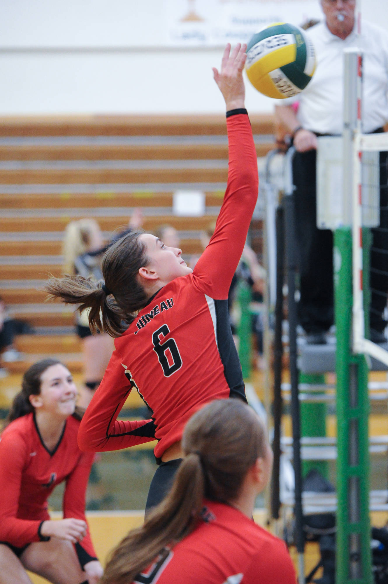Juneau-Douglas junior middle blocker Addie Prussing taps a return against Kenai as sophomore outside hitter Jenae Pusich looks on during the the Dimond-Service Tournament at Service High School in Anchorage on Friday. JDHS lost 25-19 and 25-22. (Michael Dinneen | For the Juneau Empire)