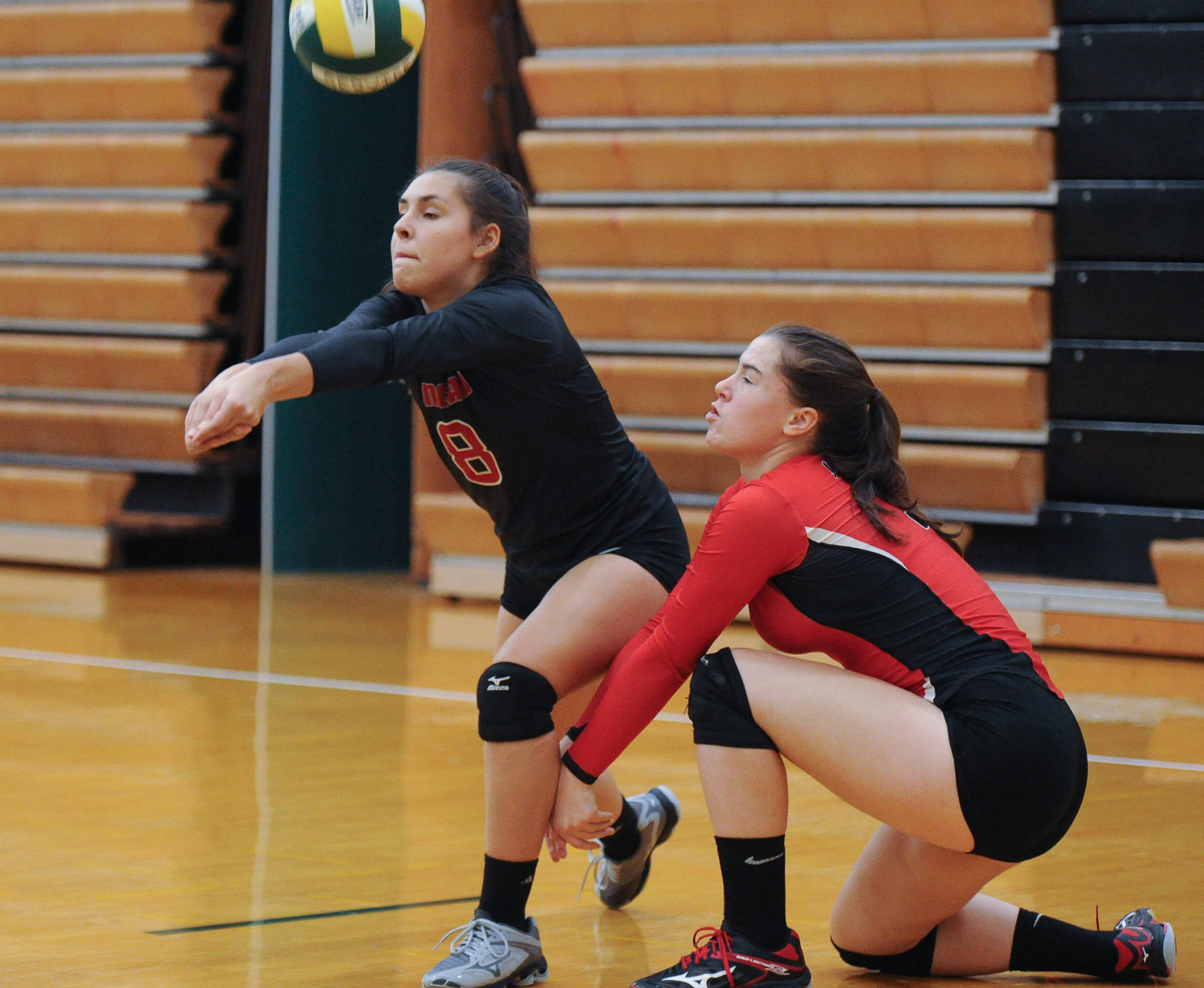 From left, Juneau-Douglas’ Miranda Mitchell and Abby Dean combine on a return of serve against Kenai during the Dimond-Service Tournament at Service High School in Anchorage on Friday. The Crimson Bears lost to the Kardinals 25-19 and 25-22. (Michael Dinneen | Juneau Empire)