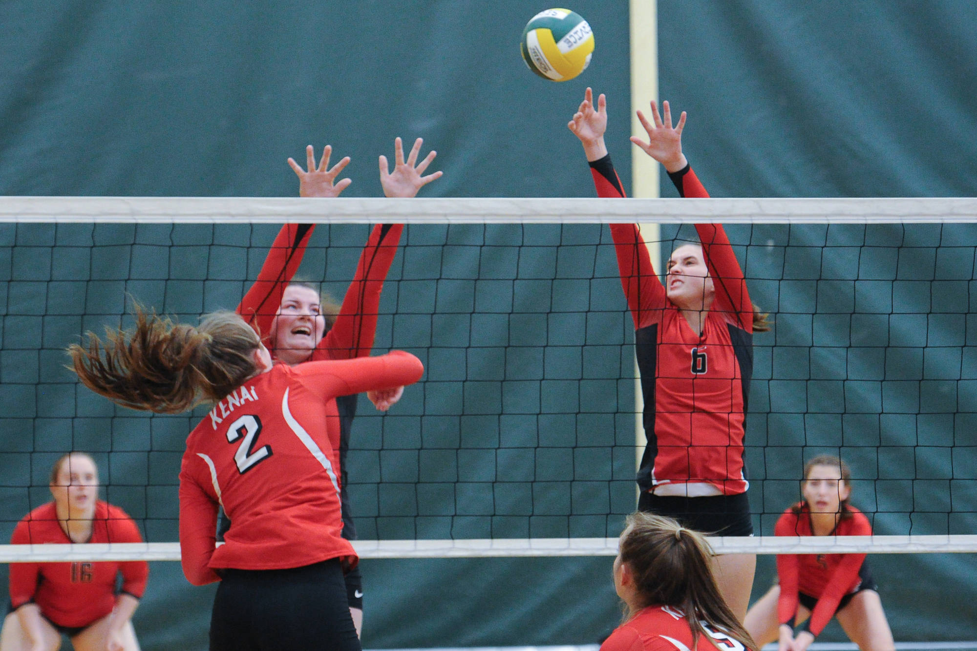 From left, Juneau-Douglas’ Gabi Griggs and Addie Prussing block a shot by Kenai’s Bethany Morris. The Crimson Bears lost to the Kardinals 25-19 and 25-22. (Michael Dinneen | For the Juneau Empire)
