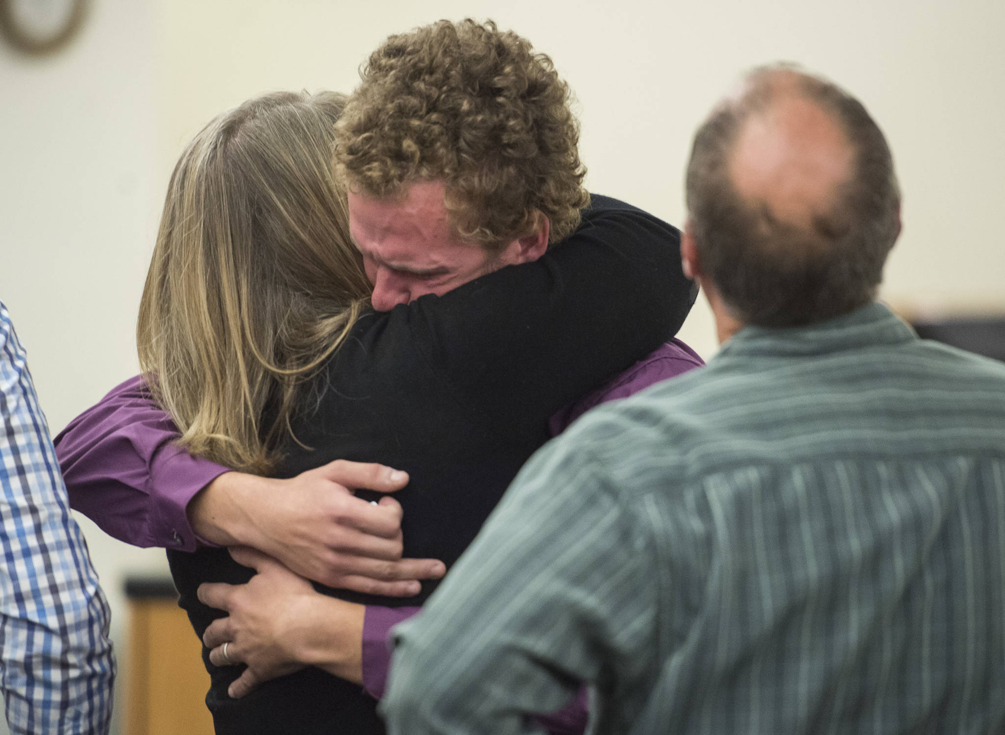 Ty Grussendorf, 24, center, hugs his parents after pleading guilty to two counts of sexual abuse of a minor in Juneau Superior Court on Monday, Oct. 22, 2018. (Michael Penn | Juneau Empire)