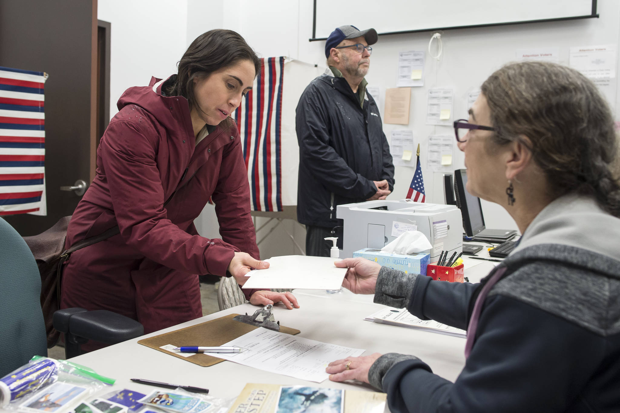 Libby Bakalar, left, receives her ballot from election official Tami Burgett, right, as Michael Grubbs waits during early voting at the State Office Building on Monday, Oct. 22, 2018. Voting is on the 8th floor of the State Office Building from 8 a.m.-5 p.m., Monday-Friday. The Elections Office in the Mendenhall Mall Annex is also open for voting during the same times plus Saturday, Nov. 3, 10 a.m.-4 p.m., and Sunday, Nov. 4, noon-4 p.m. (Michael Penn | Juneau Empire)