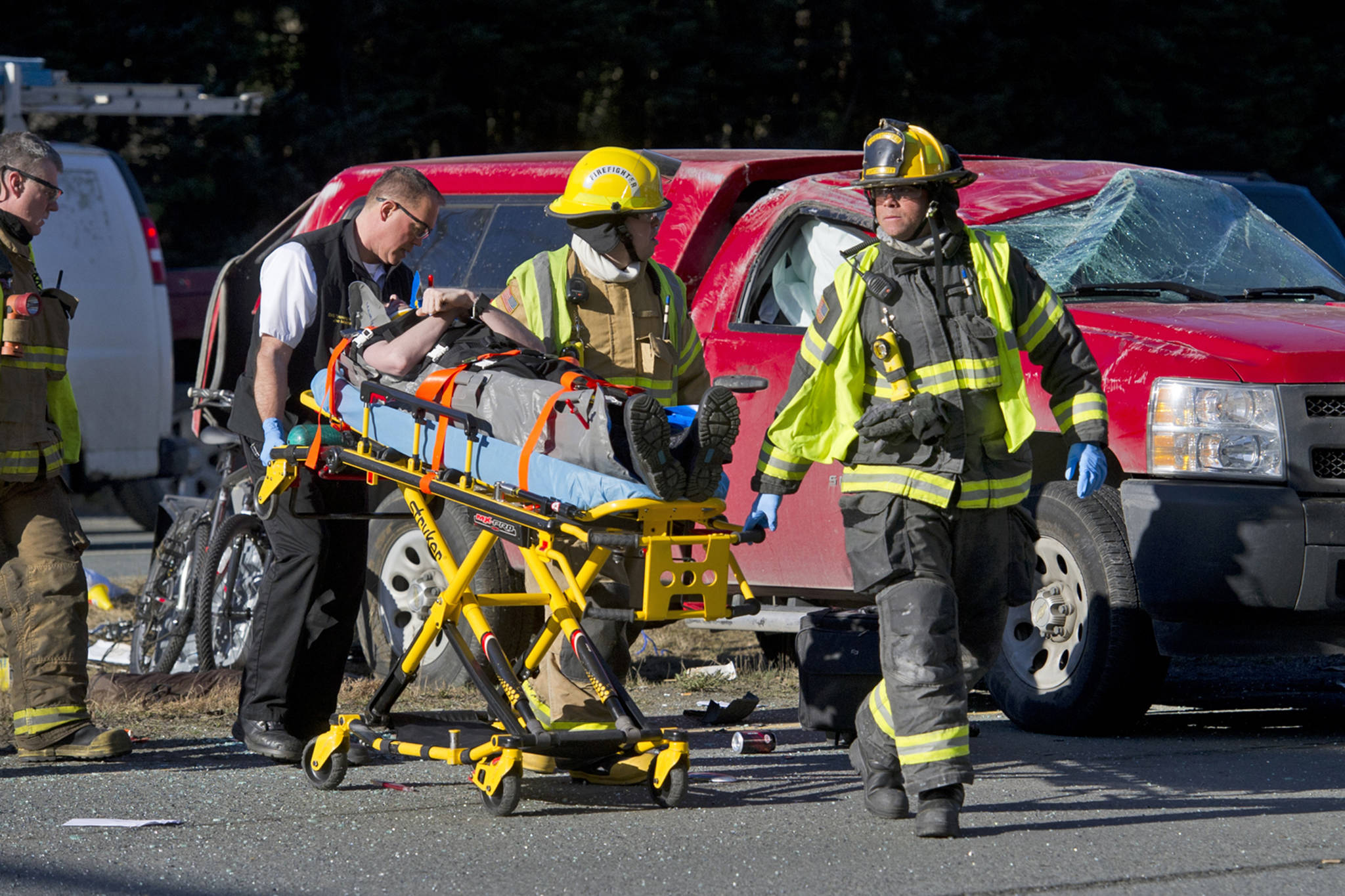 Capital City Fire/Rescue personnel wheel a man to a waiting ambulance at the scene of a two-car accident near the Egan Drive and Mendenhall Loop Road intersection in the Mendenhall Valley in March 2016. Two people were treated at Bartlett Regional Hospital for minor injuries. (Michael Penn | Juneau Empire File)