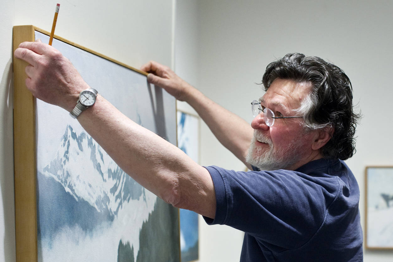 Dan Fruits hangs his paintings at the Juneau-Douglas City Museum as he readies for a summer-long exhibit. Fruits’ latest project has been paintings to be projected during the opera commissioned by the Orpheus Project will mark the 100th anniversary of the sinking of the Princess Sophia, which claimed the lives of more than 350 people. (Michael Penn | Juneau Empire)