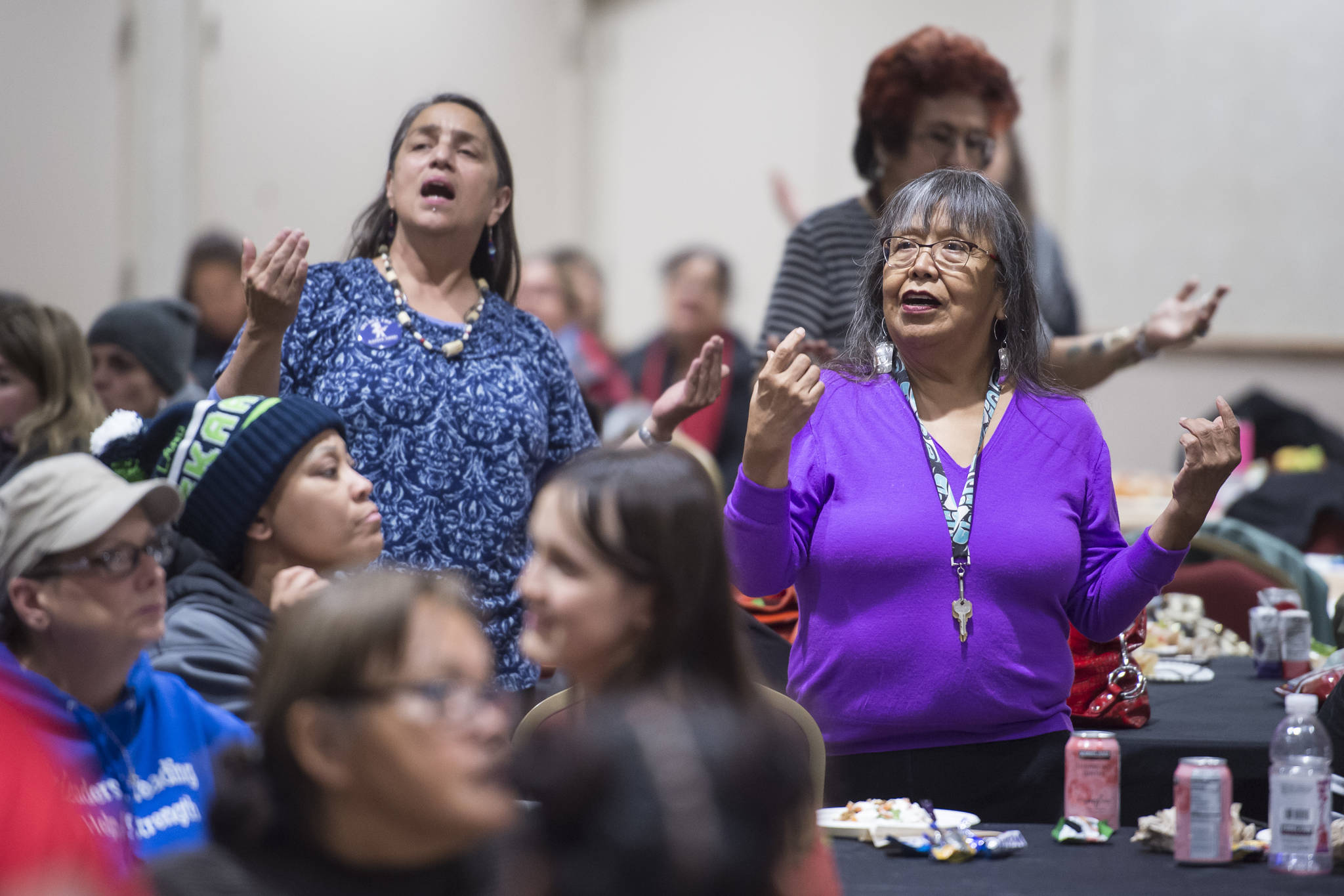 Nancy Keen, left, and Leona Santiago, right, pay tribute to the Woosh.ji.een Dance Group as they perform during a Celebrate Survivors gathering sponsored by Central Council Tlingit and Haida Indian Tribes of Alaska and AWARE in the Elizabeth Peratrovich Hall on Tuesday, Oct. 23, 2018. October is Domestic Violence Awareness Month. (Michael Penn | Juneau Empire)