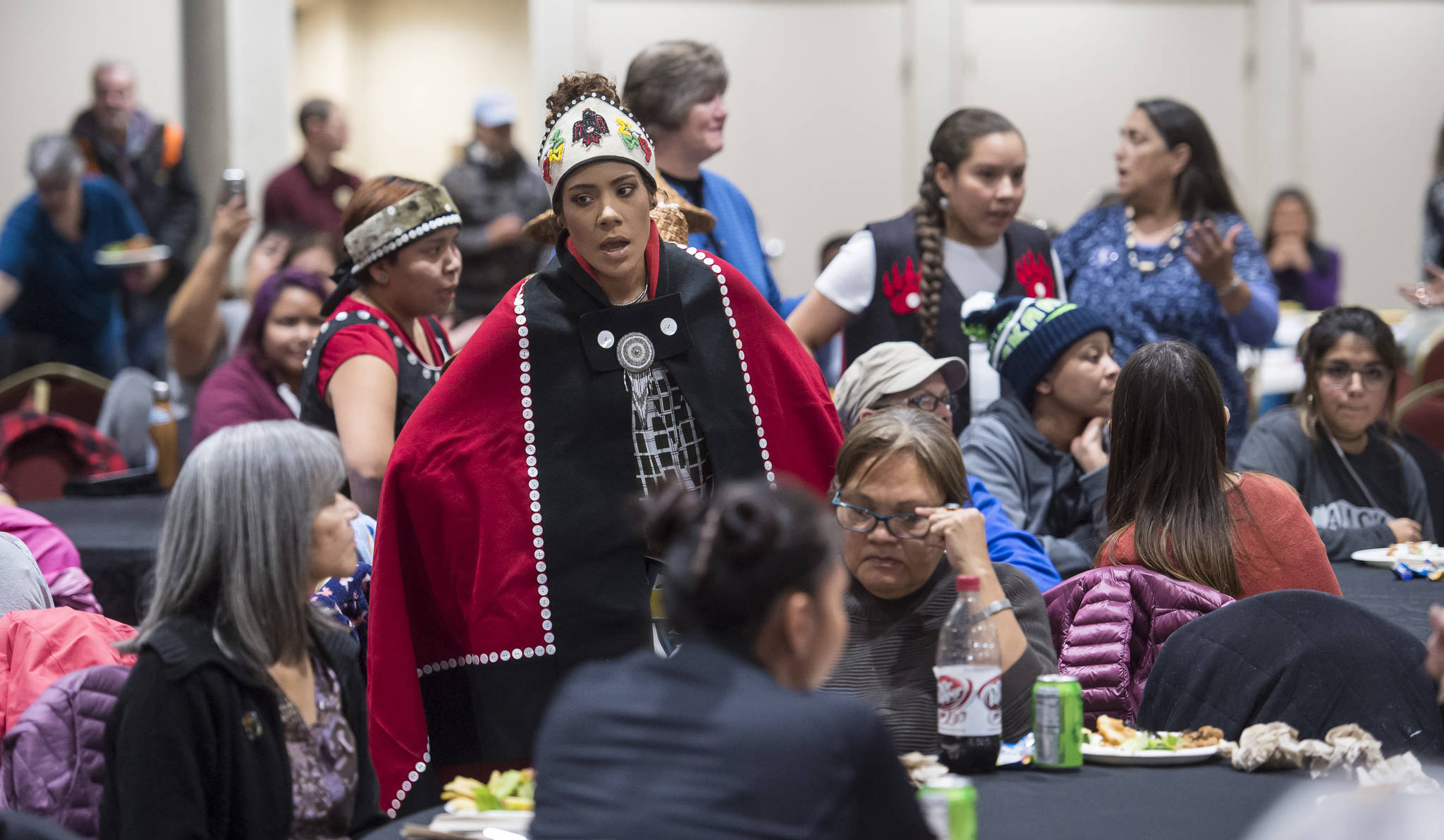 Members of the Woosh.ji.een Dance Group dance dance between tables of people attending a Celebrate Survivors gathering sponsored by Central Council Tlingit and Haida Indian Tribes of Alaska and AWARE in the Elizabeth Peratrovich Hall on Tuesday, Oct. 23, 2018. October is Domestic Violence Awareness Month. (Michael Penn | Juneau Empire)