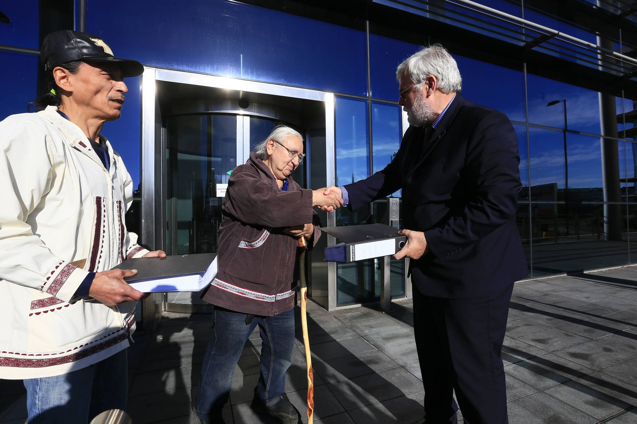 George Edwardson, board member for Inuit Circumpolar Council-Alaska and President of the Inupiat Community of the Arctic Slope (ICAS) hands the first of three binders holding over 104,000 signatures on an international petition calling for Carnival Corporation to end its use of heavy fuel oil in the Arctic and Subarctic to Tom Strang, Senior Vice President of Maritime Affairs for cruise industry giant. In July this year, the Inuit Circumpolar Council issued a formal Declaration calling for a phaseout of heavy fuel oil in the region. (Courtesy Photo | Jiri Rezac via Stand.earth)