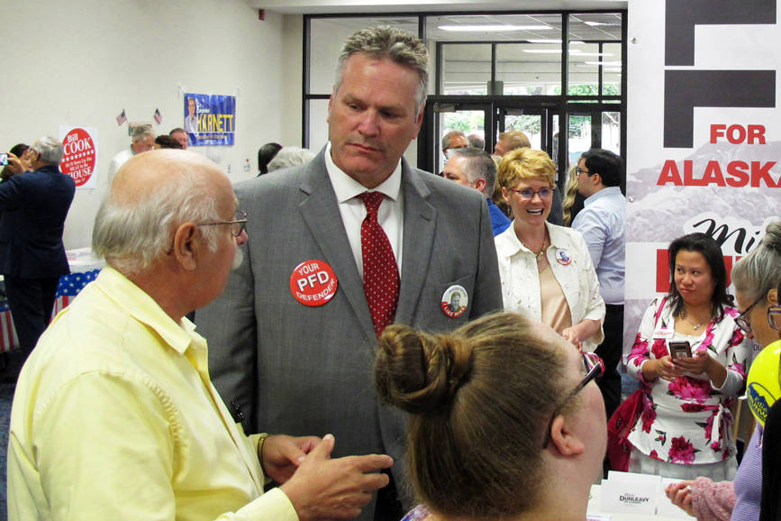 In this Aug. 19 file photo, Republican gubernatorial candidate Mike Dunleavy, second from left, stands near his campaign table at a meet-and-greet event in the lobby of Anchorage Baptist Temple in Anchorage. (Becky Bohrer | The Associated Press File)