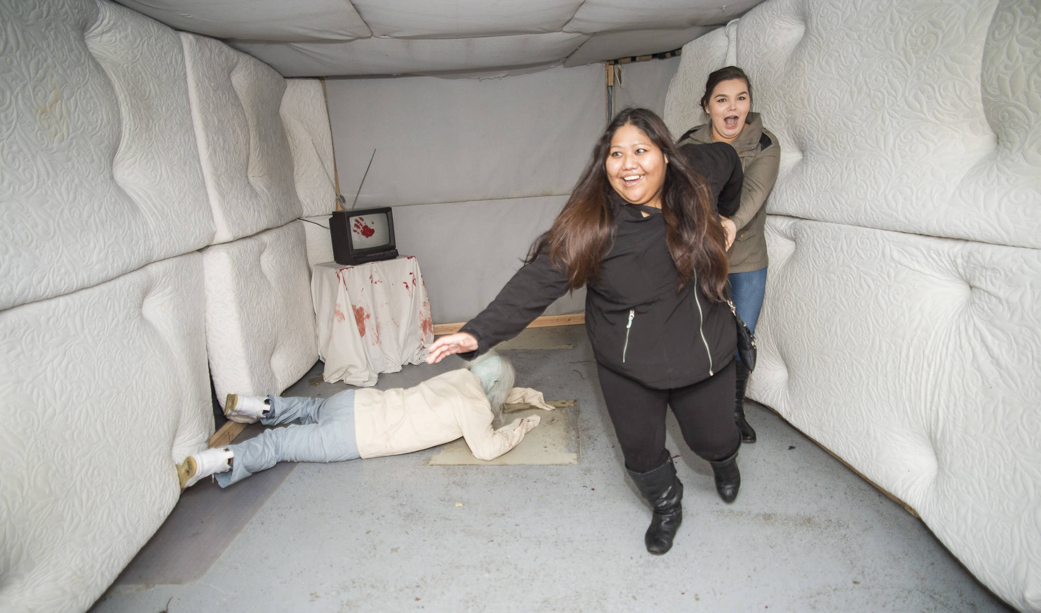 Juneau residents react to scares and chills as they make their way through the Haunted Station at the U.S. Coast Guard’s Station Juneau on Friday, Oct. 26, 2018. Station personnel pay for all the decoration themselves and take three weeks to ready the station. Entry is non perishable food items for the Southeast Alaska Food Bank. (Michael Penn | Juneau Empire)