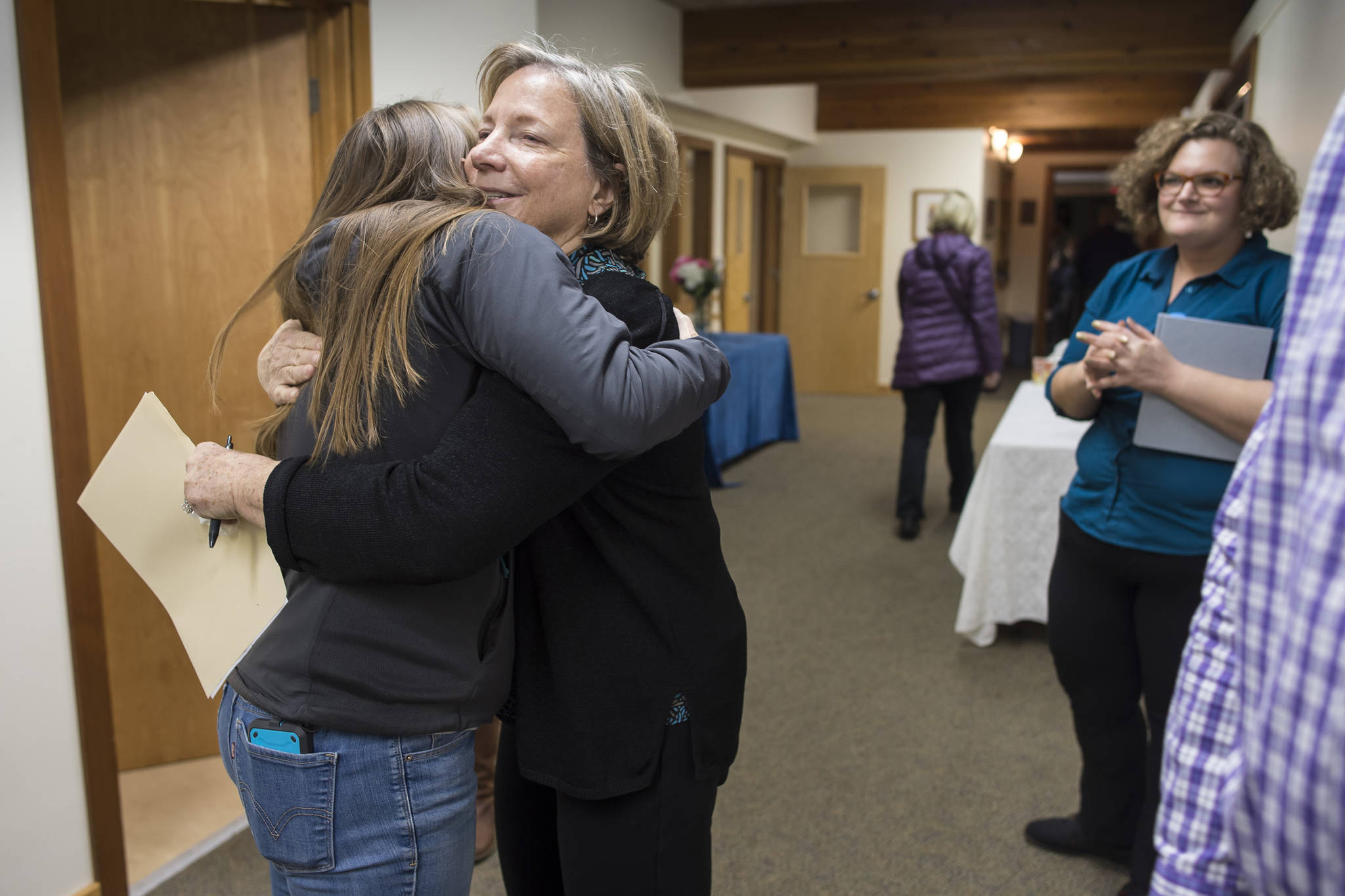Chava Lee, President of the Congreation Sukkat Shalom Board, center, hugs Melissa Goldstein during a gathering at Temple Sukkat Shalom on Tuesday, Oct. 30, 2018, to honor the memory of the 11 people killed by a gunman at the Tree of Life synagogue in Pittsburgh, Pennsylvania, on Saturday. (Michael Penn | Juneau Empire)