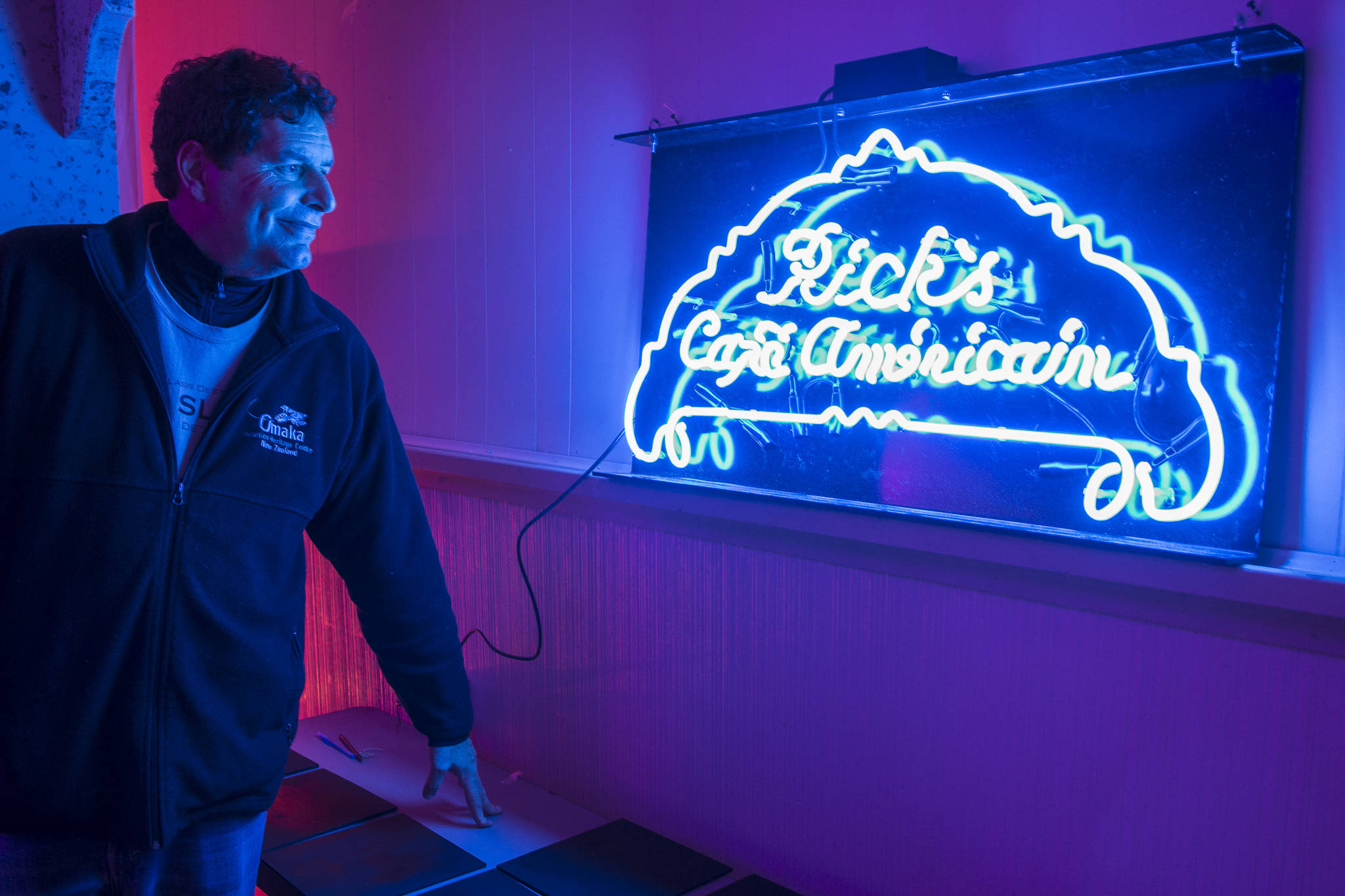 Juneau Lyric Opera boardmember John Clough admires their Rick’s Cafe Americain neon sign as they transform the Rockwell Ballroom to a 1941 Moroccian cafe for “Here’s Looking at You, Casablanca” on Monday, Nov. 5, 2018. The show is a presentation by the Juneau Lyric Opera and Gold Town Nickelodeon. (Michael Penn | Juneau Empire)
